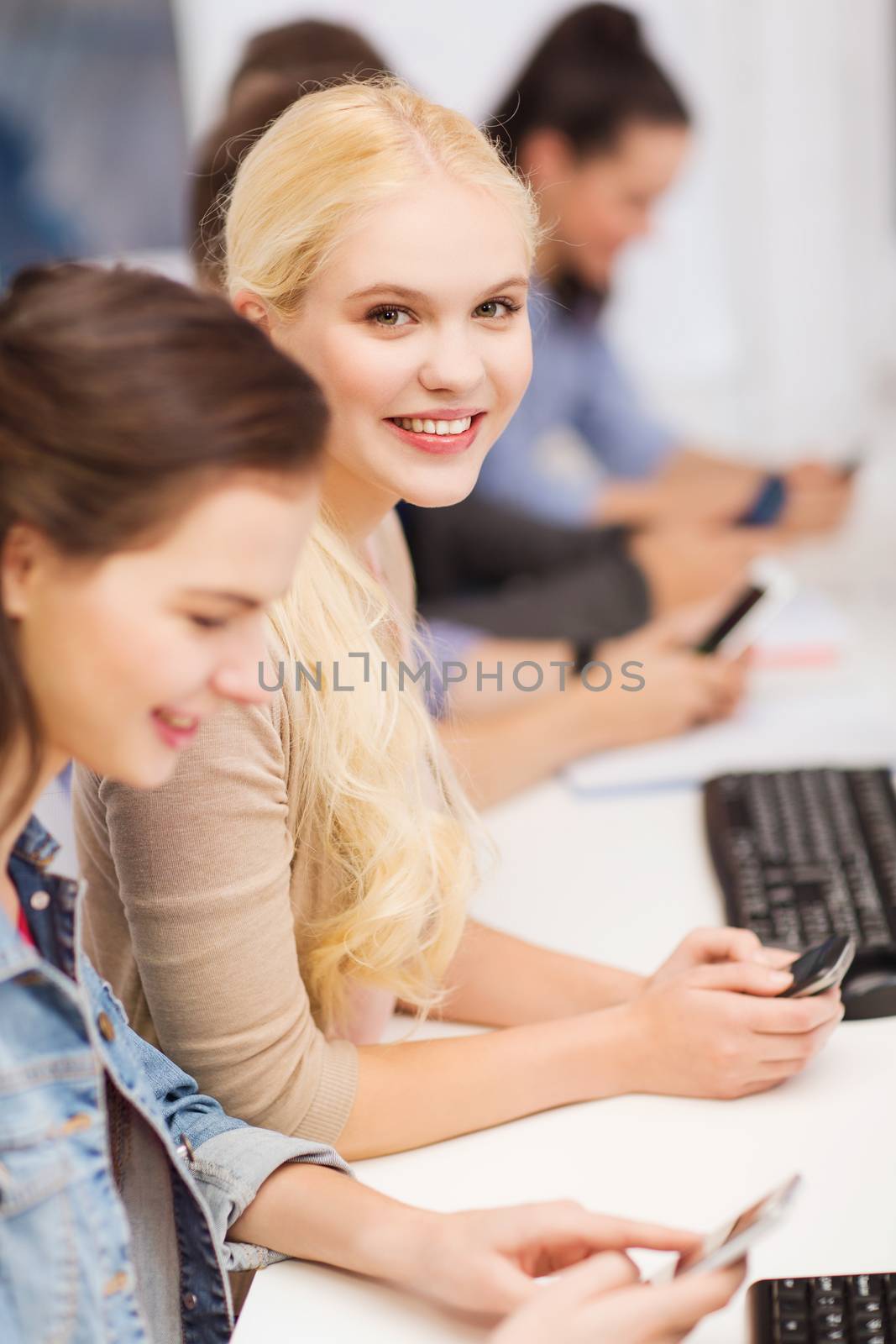 students with computer monitor and smartphones by dolgachov