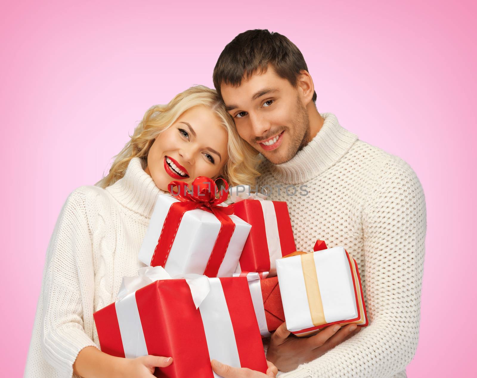 love, family and holidays concept - romantic couple in sweaters with many gift boxes