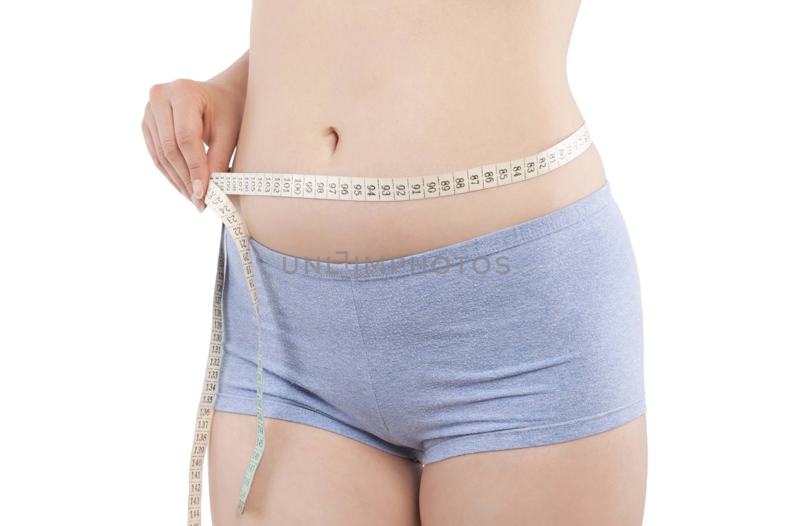 Beautiful caucasian girl measuring her hips with tape measure isolated on white background. Aesthetic medicine, weight loss and plastic surgery concept.