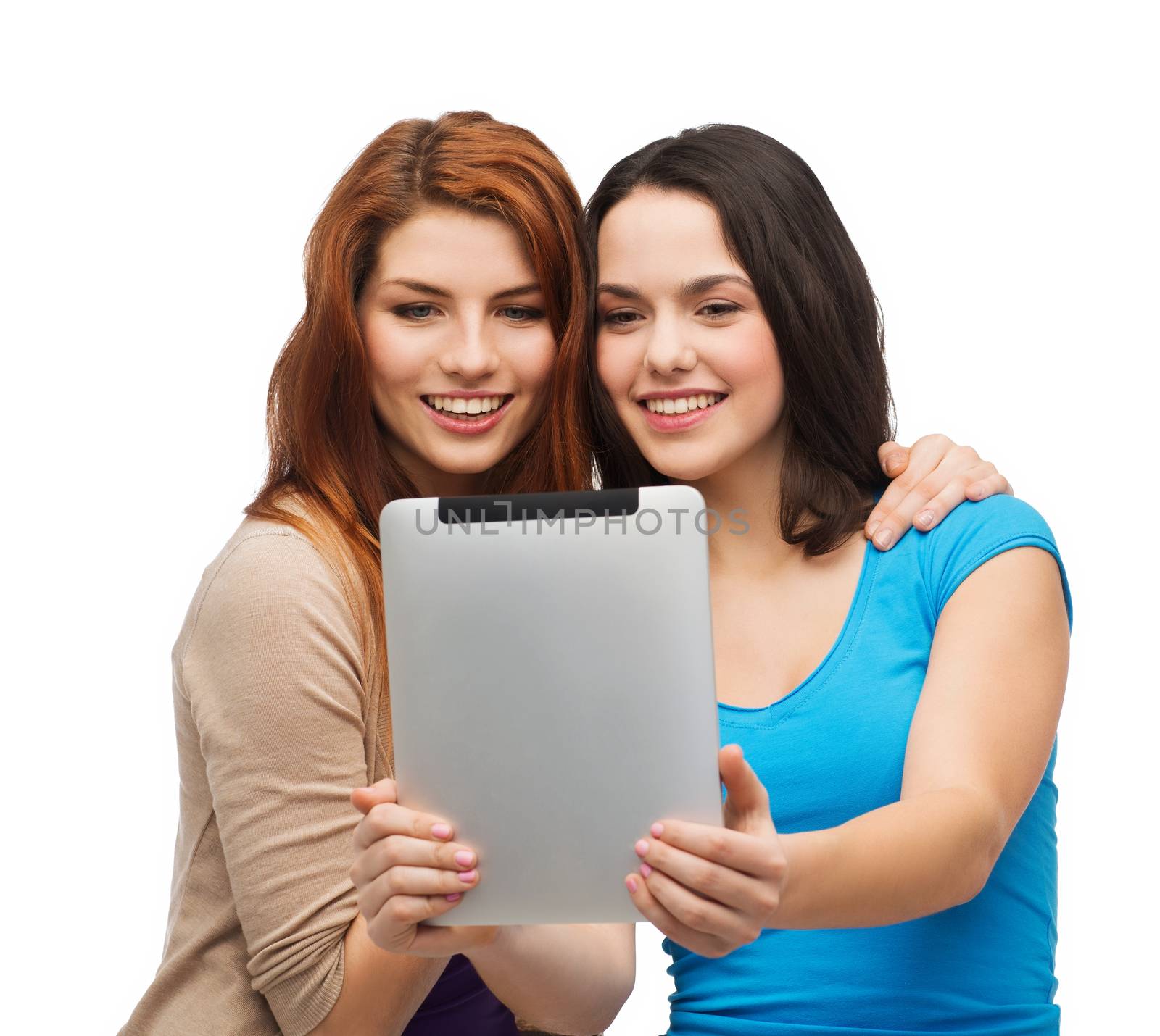 technology, friendship and people concept - two smiling teenagers taking picture with tablet pc camera