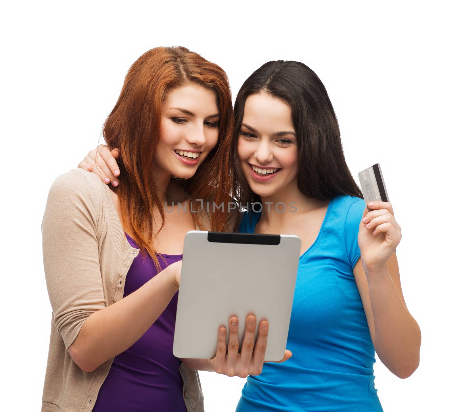 online shopping and technology concept - two smiling teenagers with tablet pc computer and credit card