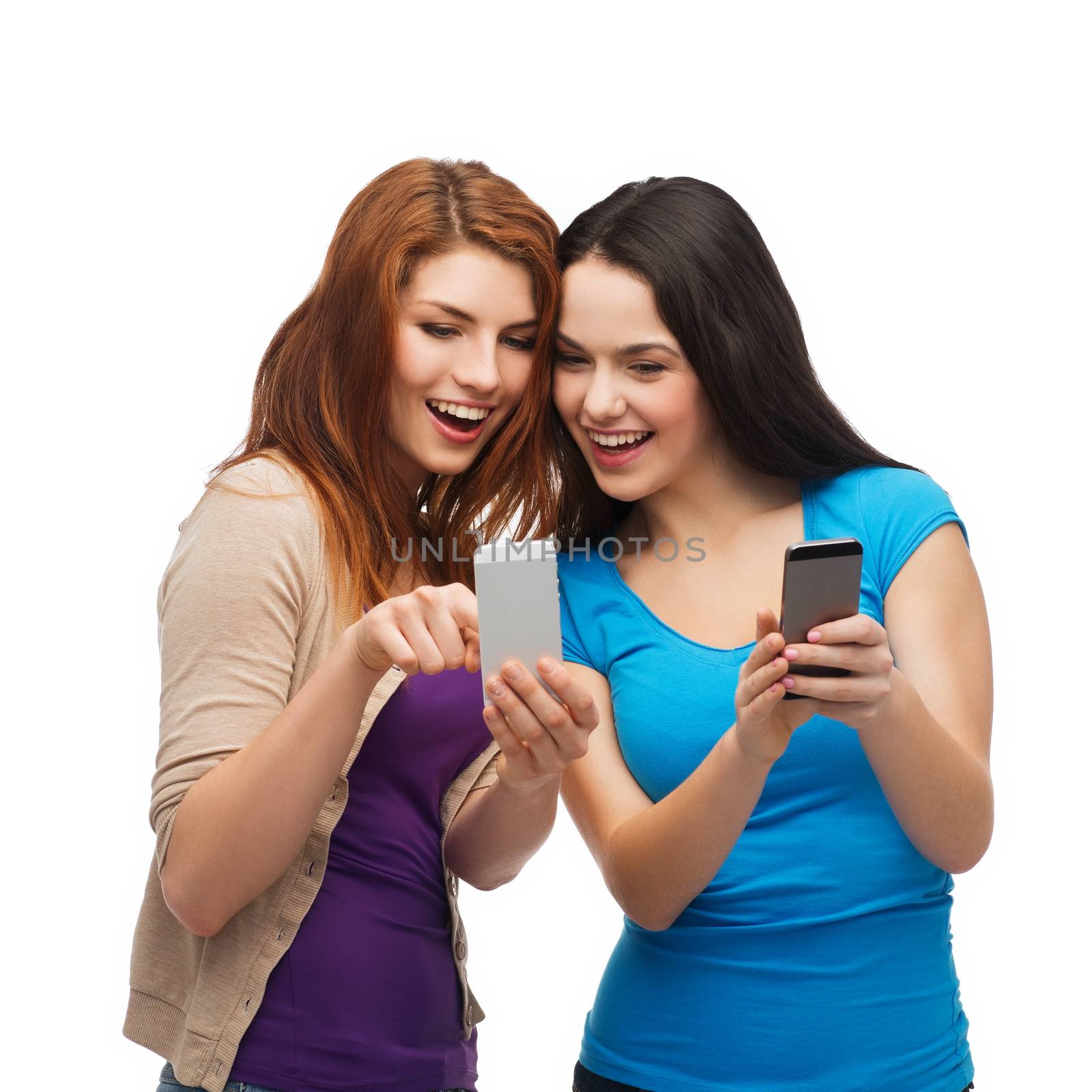 technology, friendship and people concept - two smiling teenagers pointing finger at smartphone screen