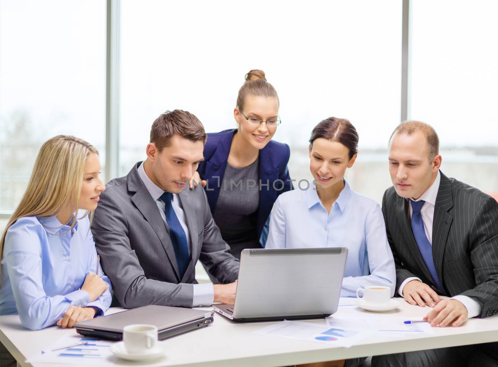 business team with laptop having discussion by dolgachov