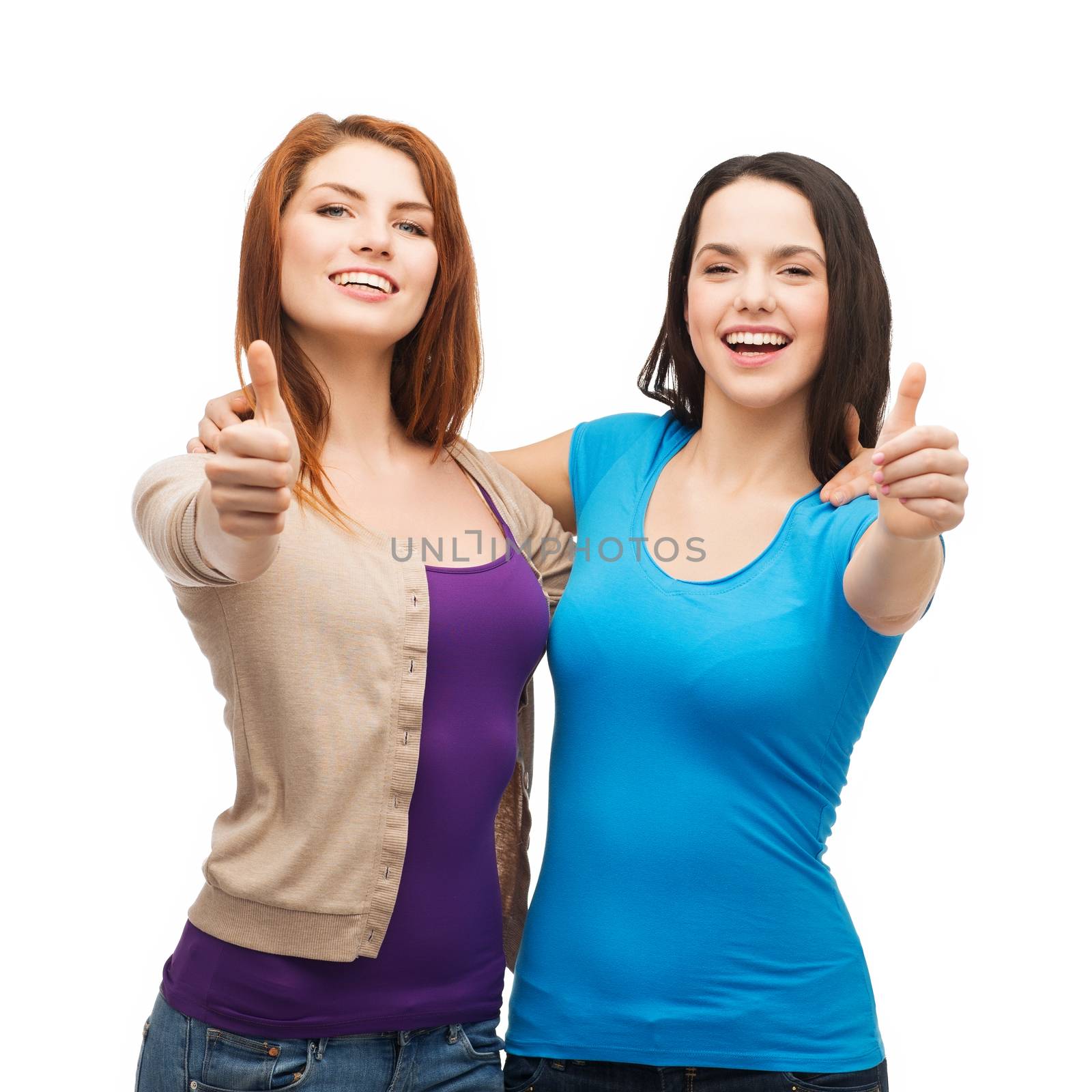 friendship and happy people concept - two smiling girls showing thumbs up