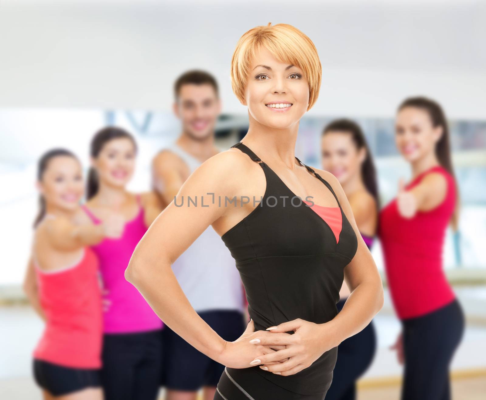 fitness, sport, training, gym and lifestyle concept - group of smiling people with trainer exercising in the gym