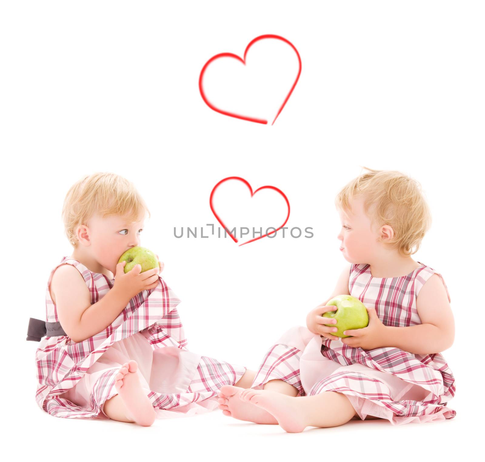 children and happiness concept - two adorable twins with apples over white