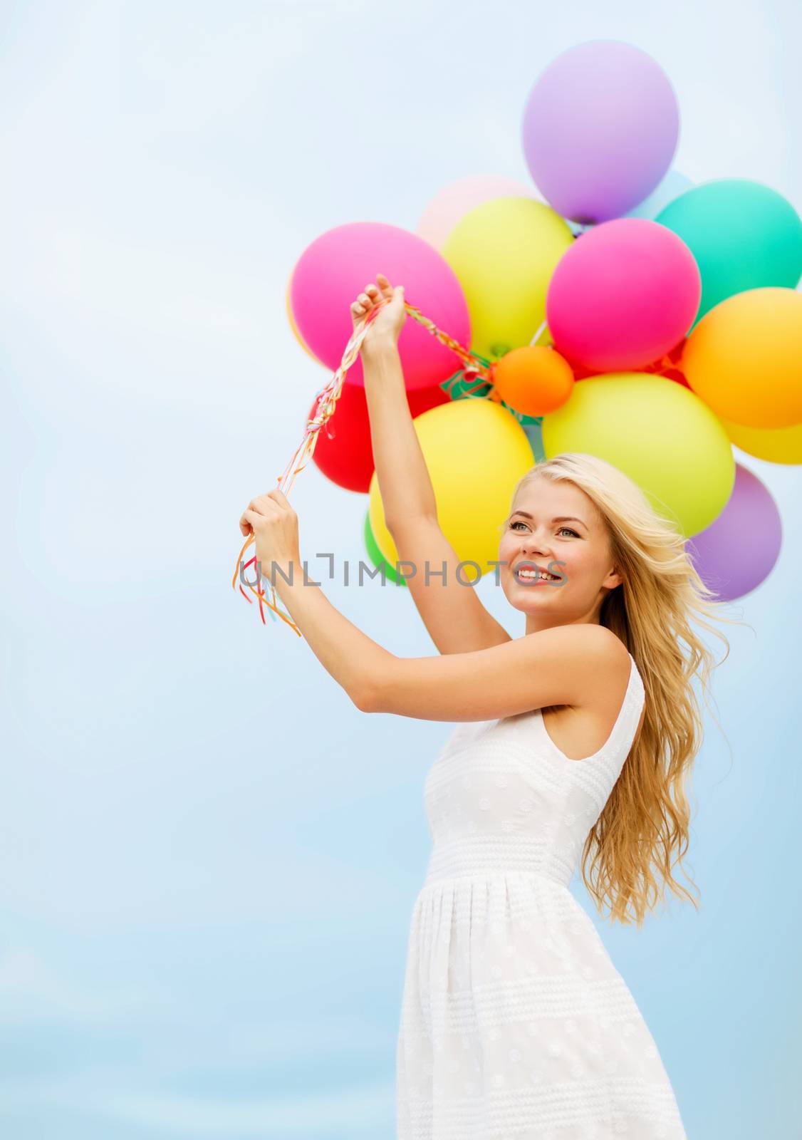 smiling woman with colorful balloons outside by dolgachov