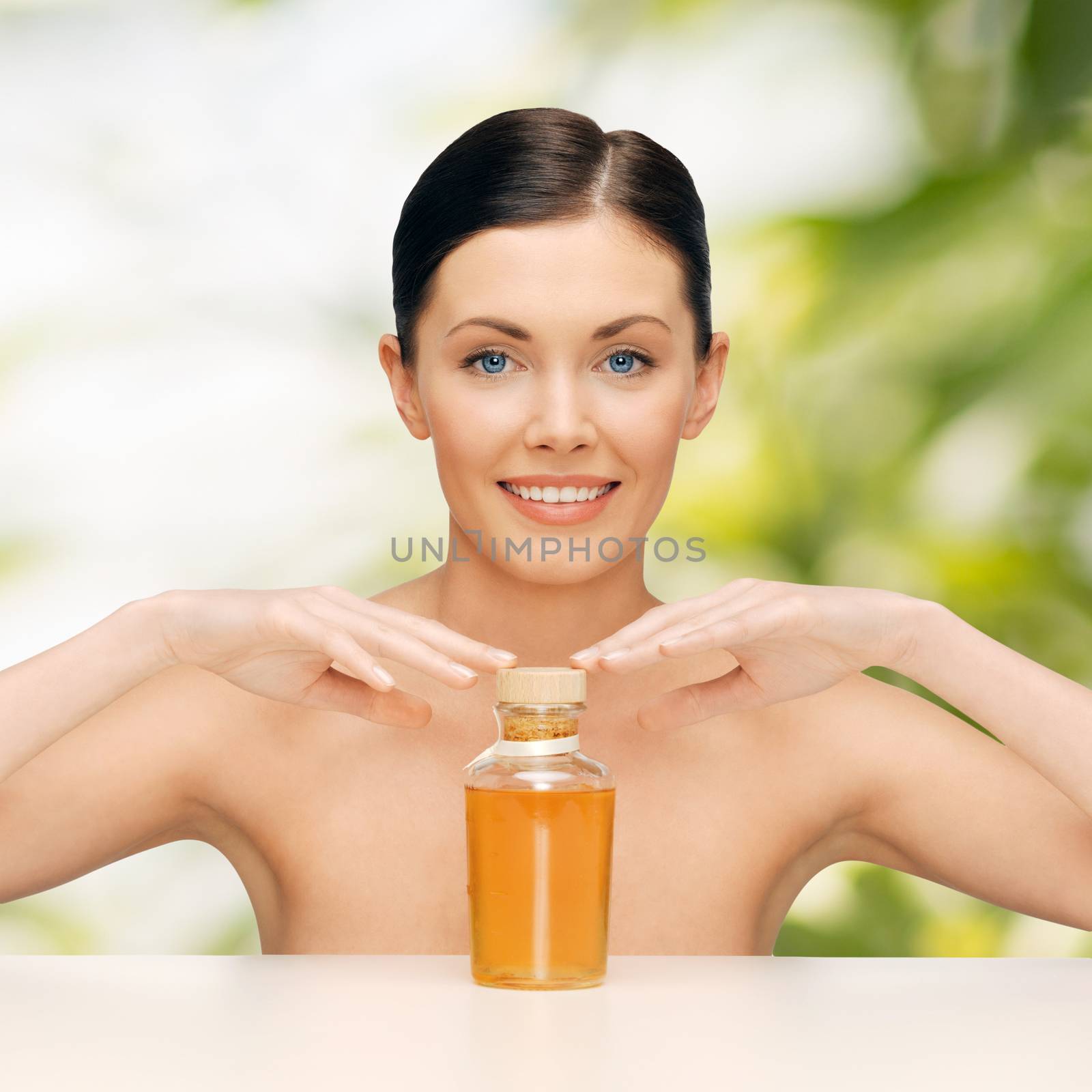 healthcare, spa and beauty concept - beautiful woman with oil bottle