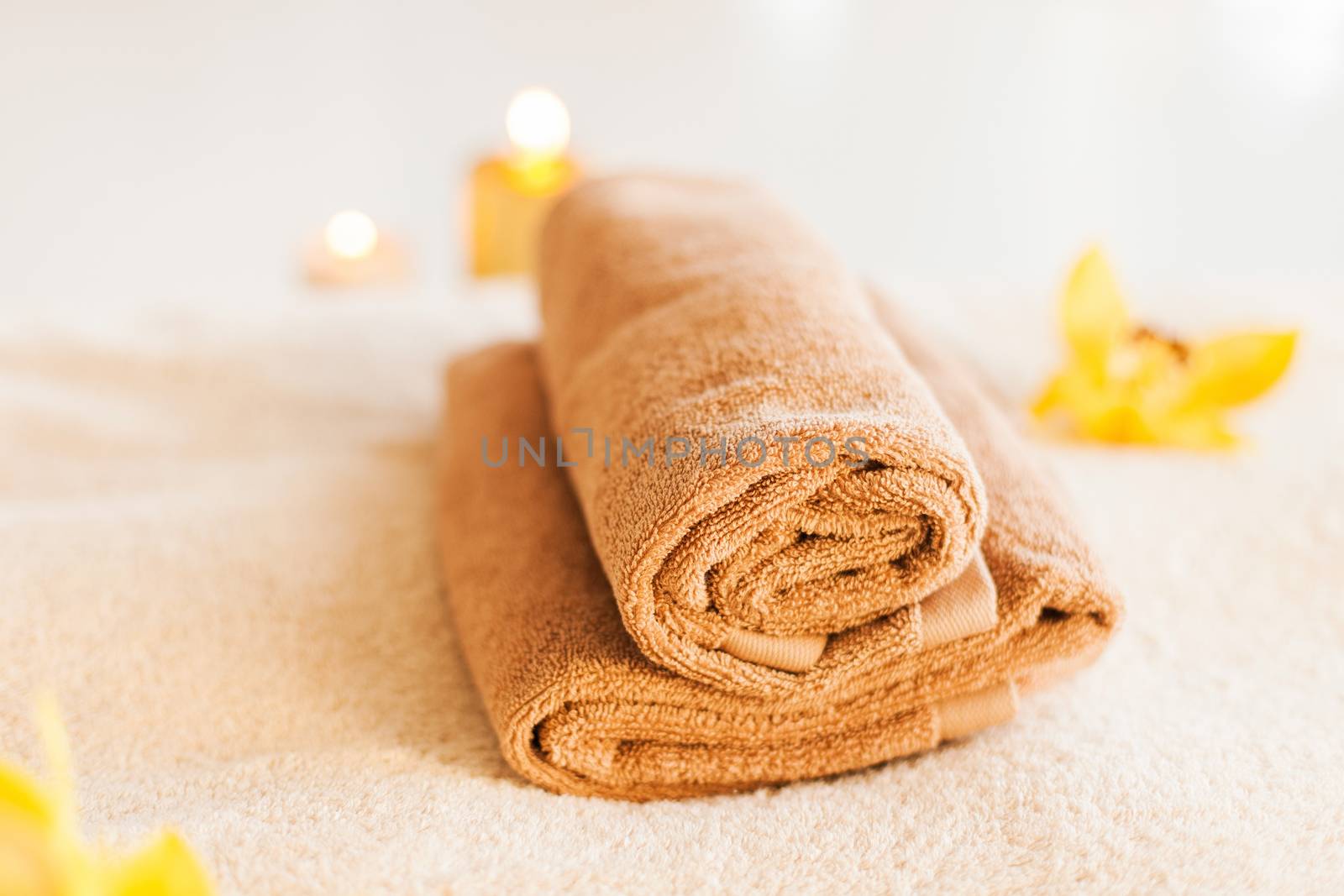 spa, health and beauty concept - closeup of towels, flowers and candles