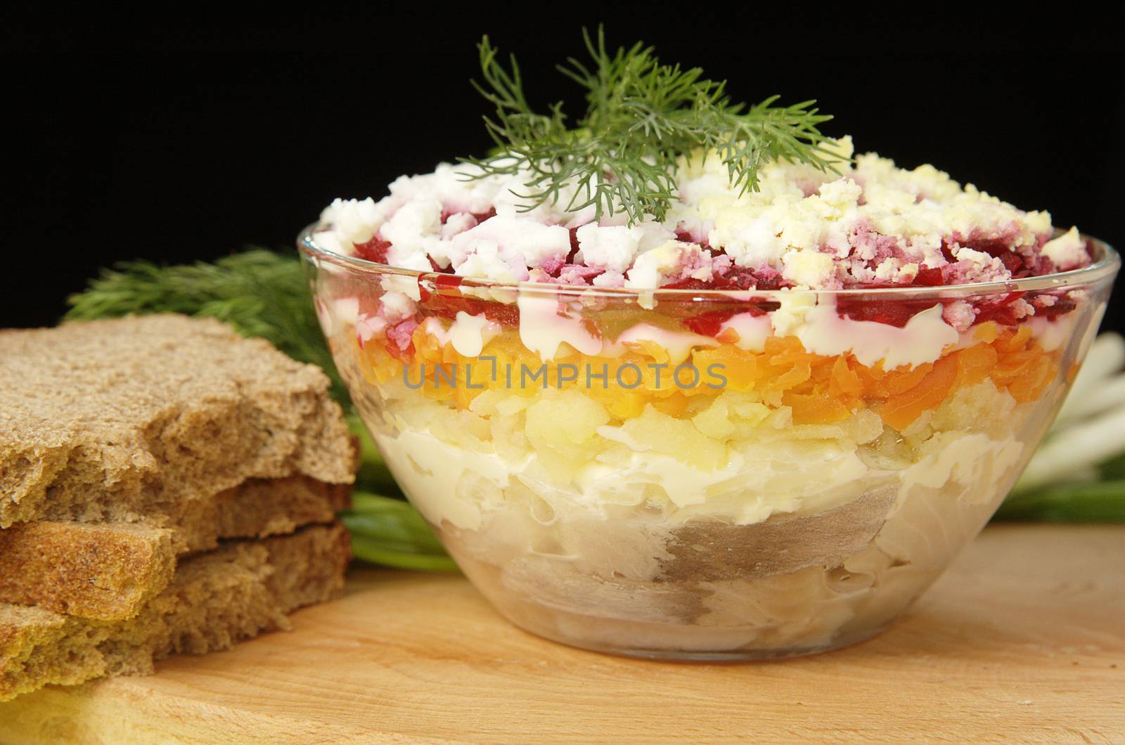 Russian traditional herring salad in glass bowl