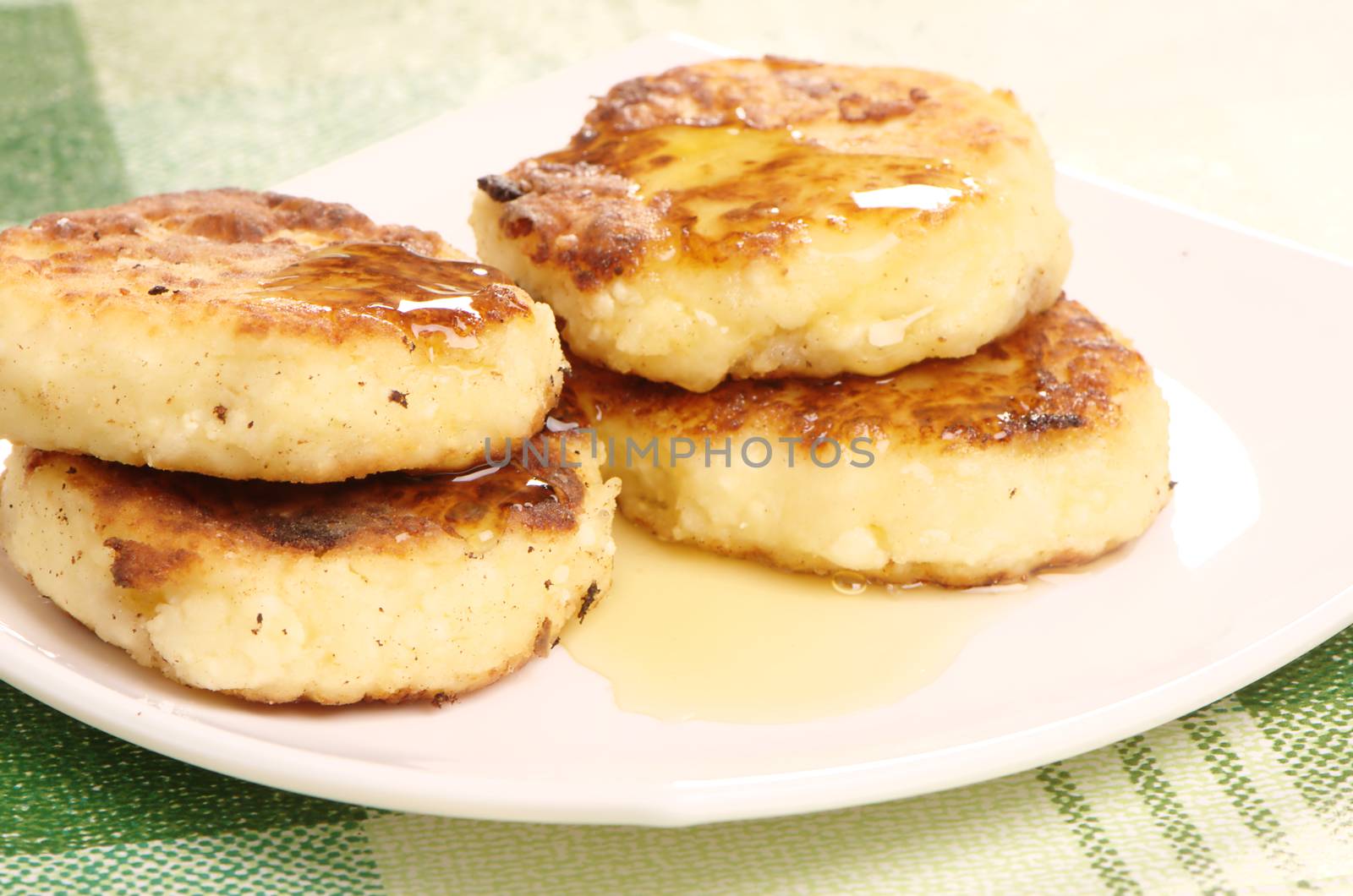 Delicious homemade cheese pancakes with honey closeup