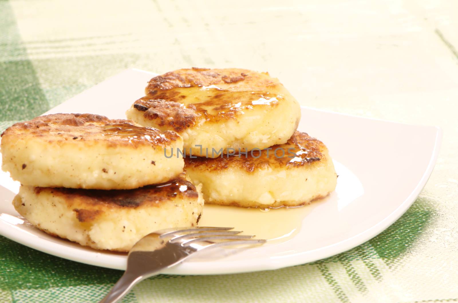 Delicious homemade cheese pancakes with honey closeup