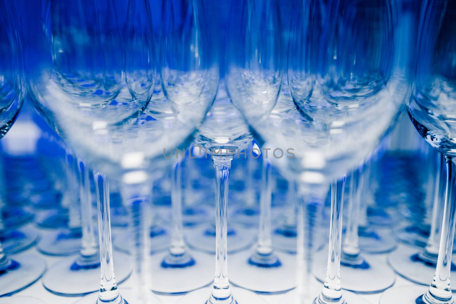 Many Empty Wineglasses Upside Down on a White reflective Table