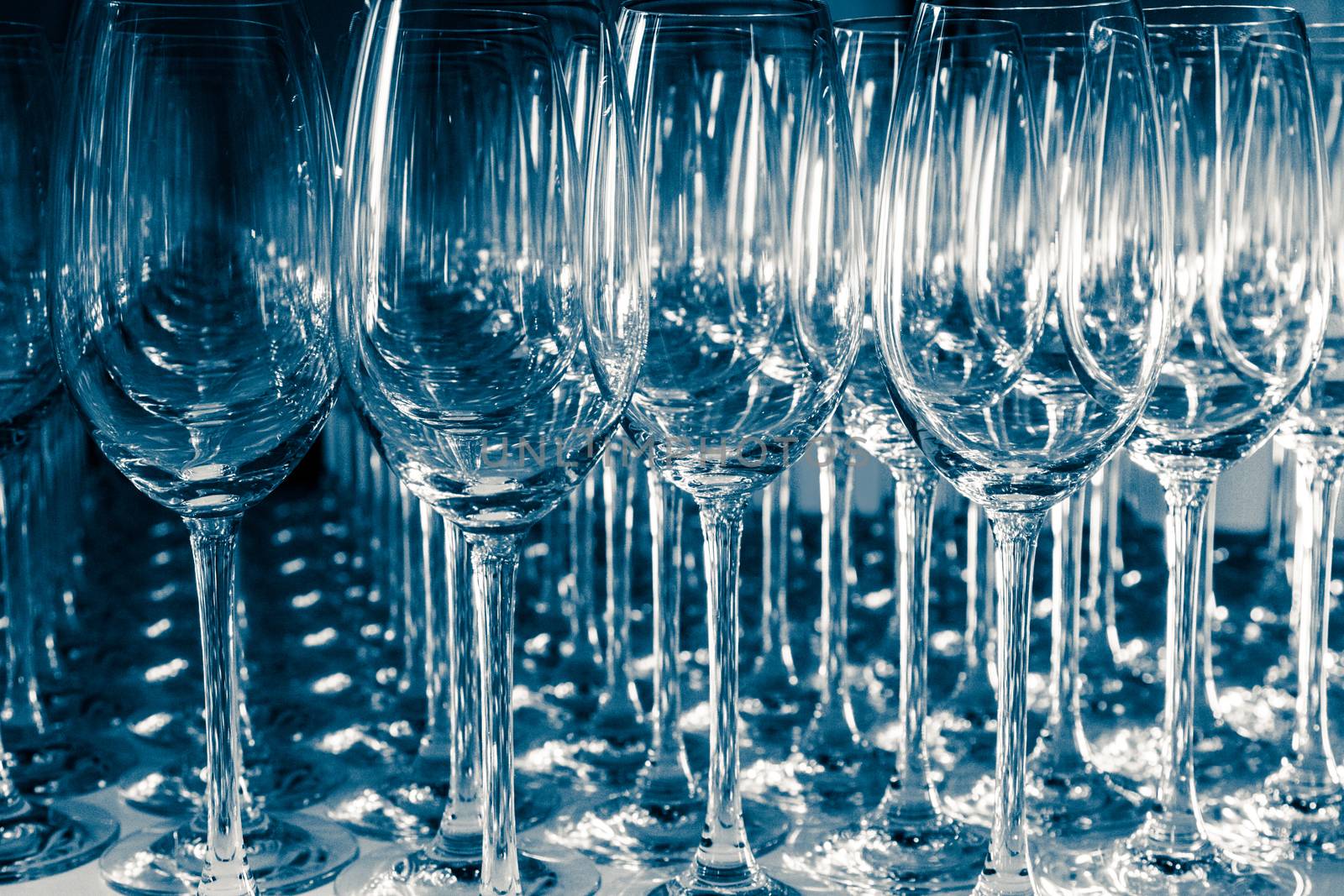 Many Empty Wineglasses Upside Down on a White reflective Table