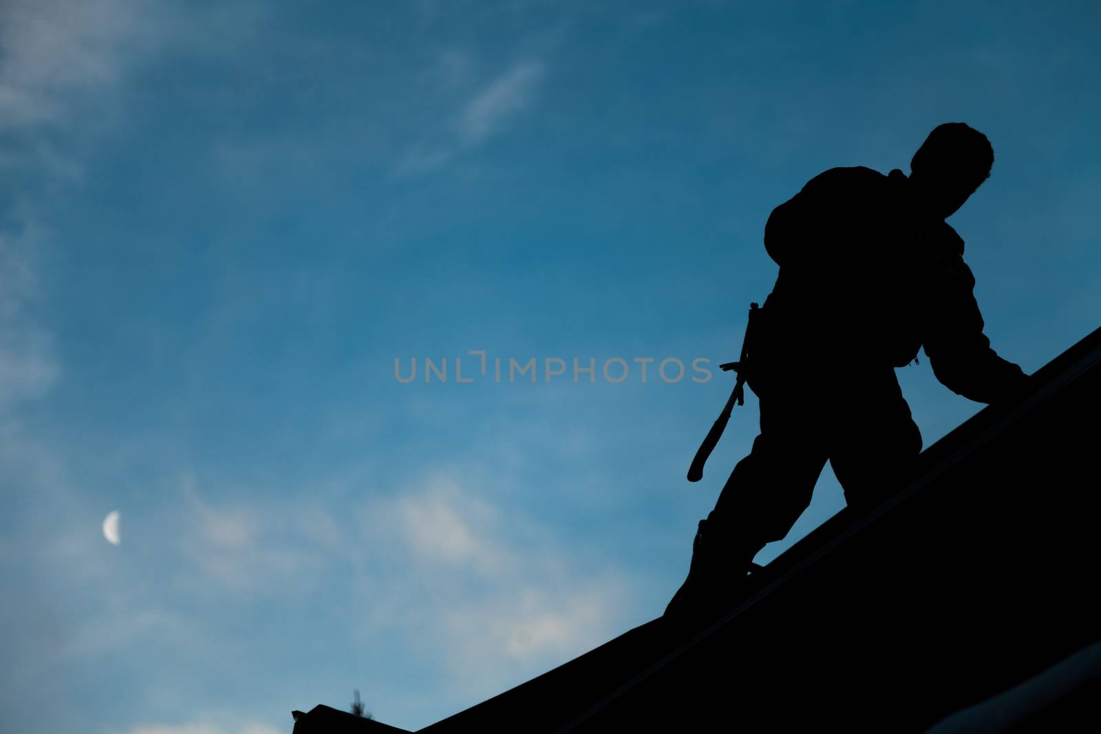 Contractor in Silhouette working on a Roof Top by aetb