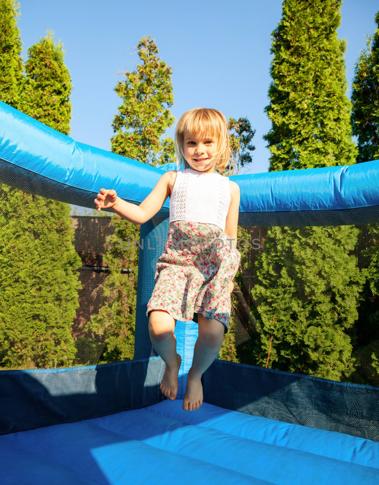 Happy girl jumping on inflatable playground