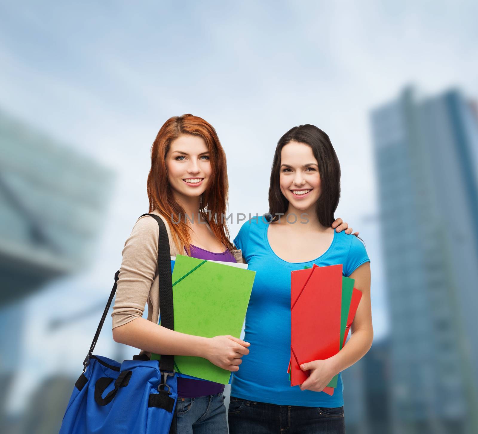 education and people concept - two smiling students with bag and folders standing