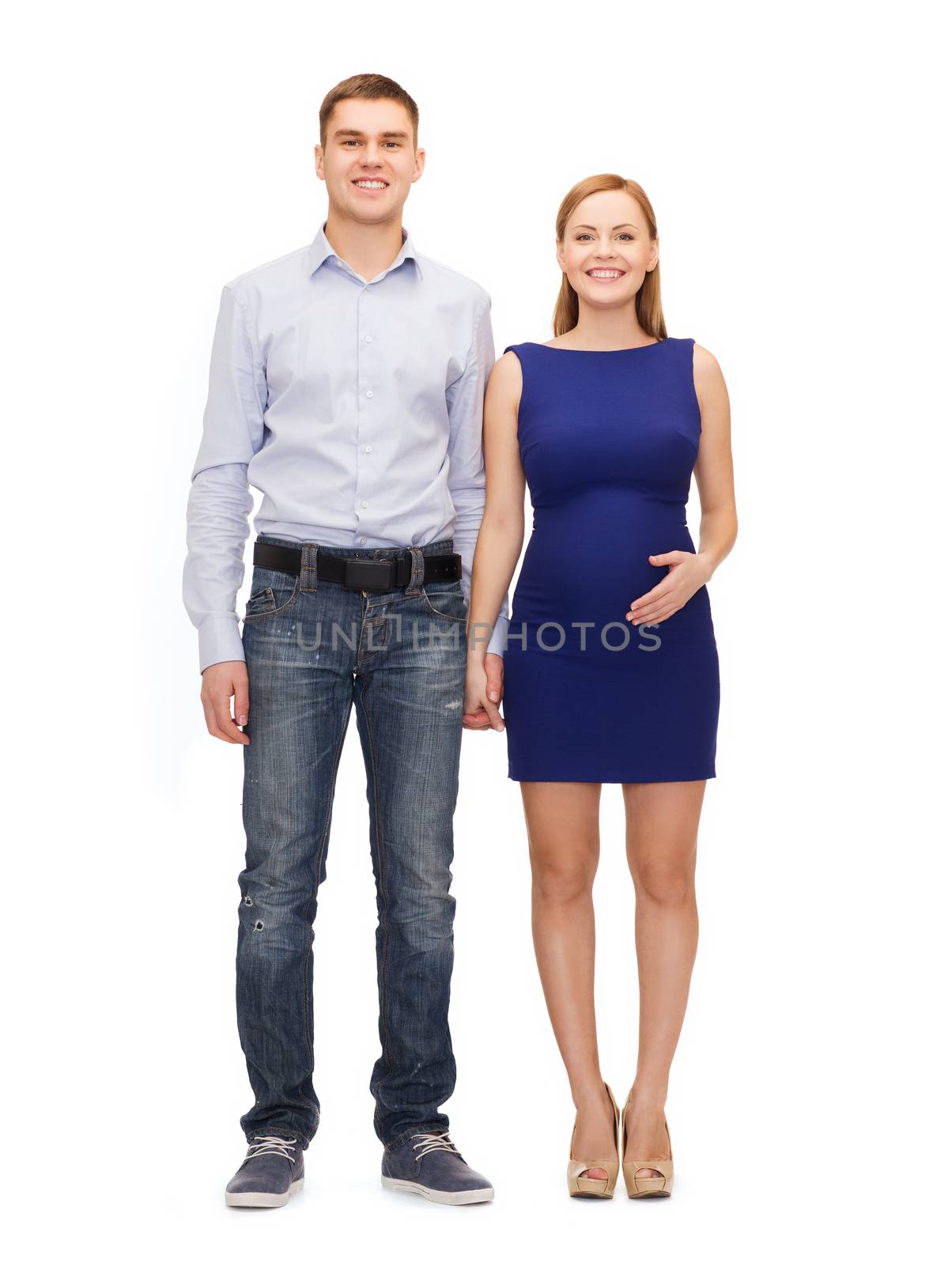 pregnancy, parenthood and happiness concept - happy young family expecting child holding hands