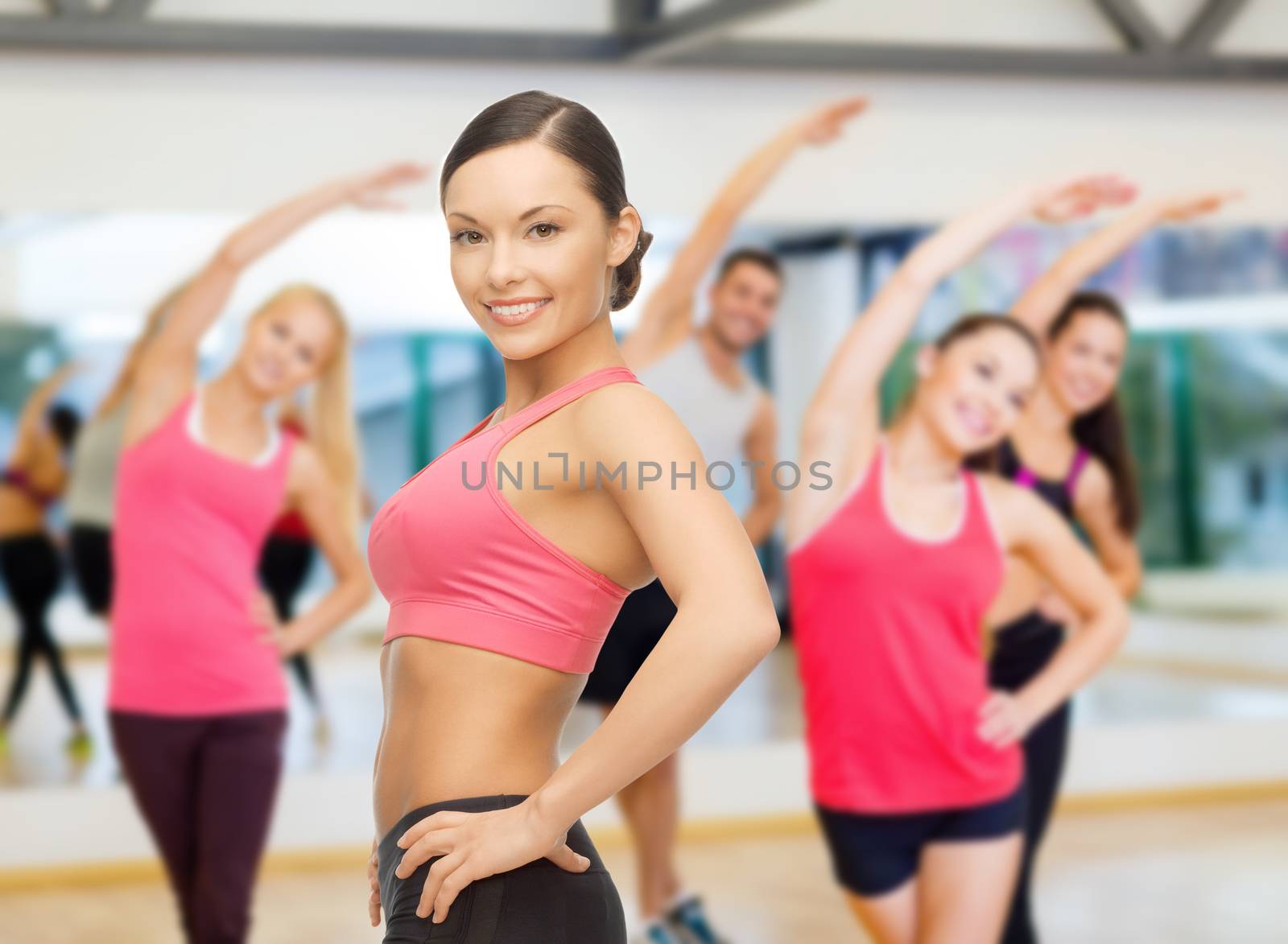 fitness, sport, training and lifestyle concept - personal trainer with group of smiling people in gym