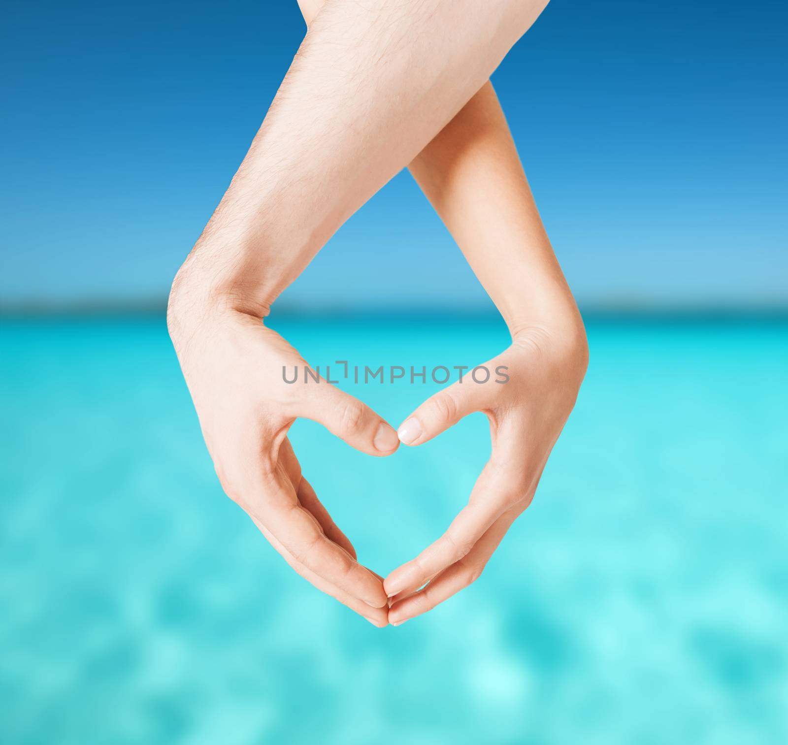 love, summer holidays and vacation concept - close up of woman and man hands showing heart shape