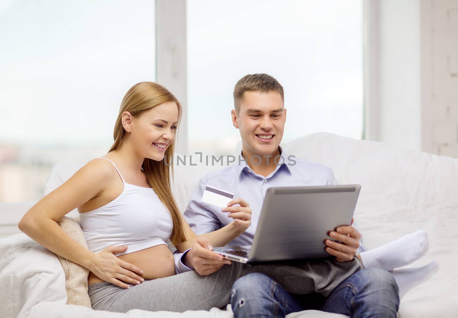 expecting family with laptop and credit card by dolgachov