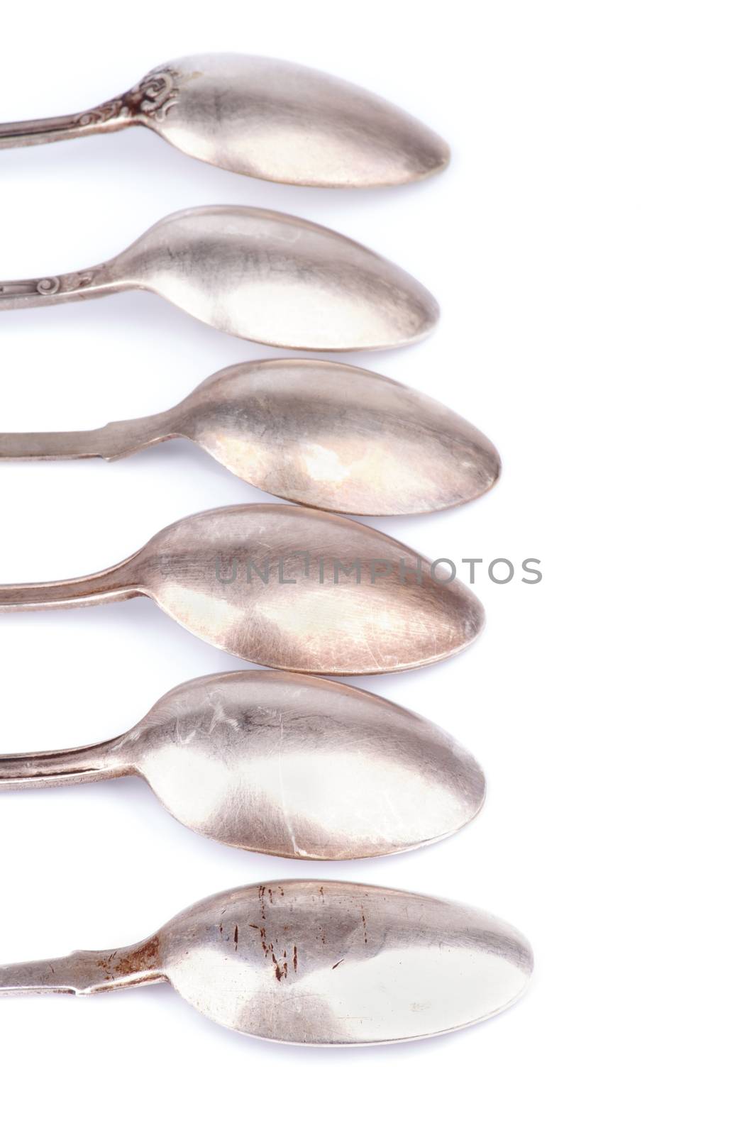 Frame of Old Silver Spoons In a Row isolated on white background