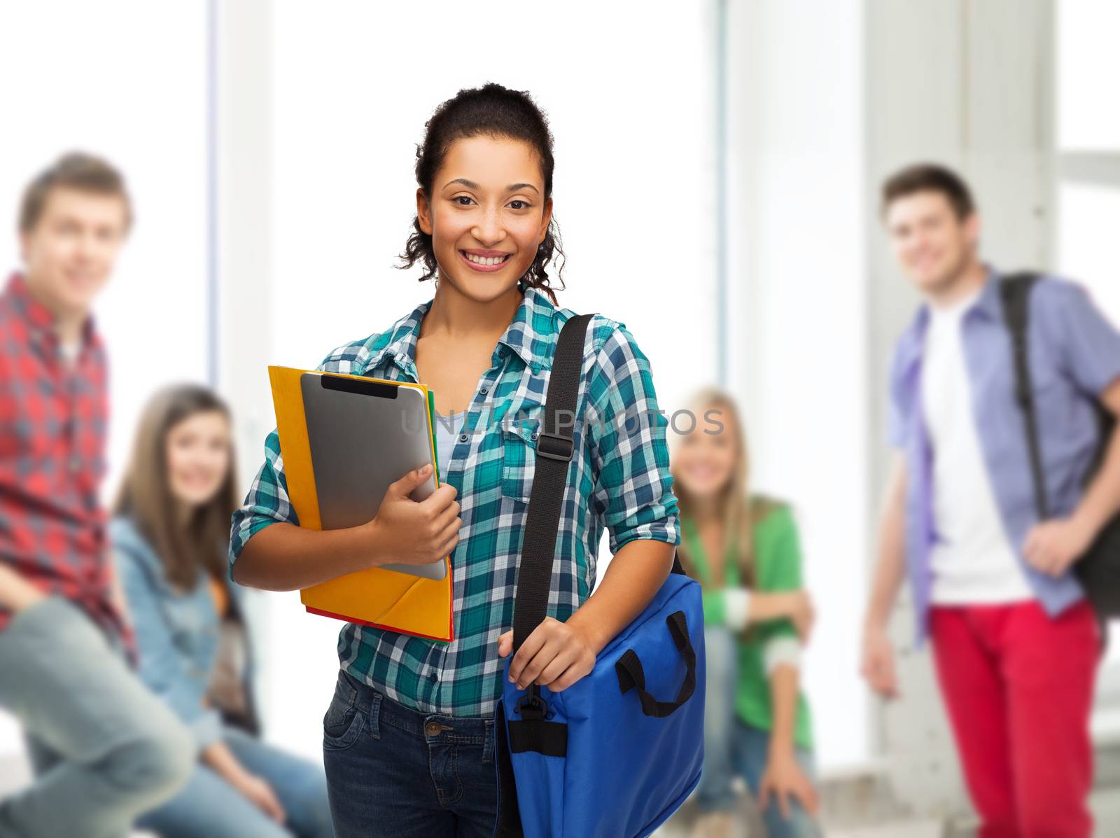 smiling student with folders, tablet pc and bag by dolgachov