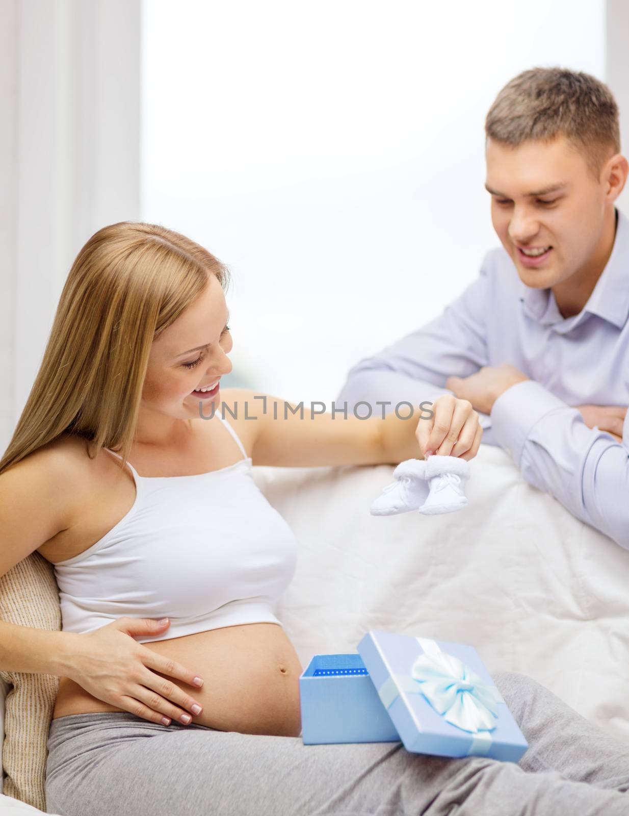 family expecting child with gift box and bootees by dolgachov