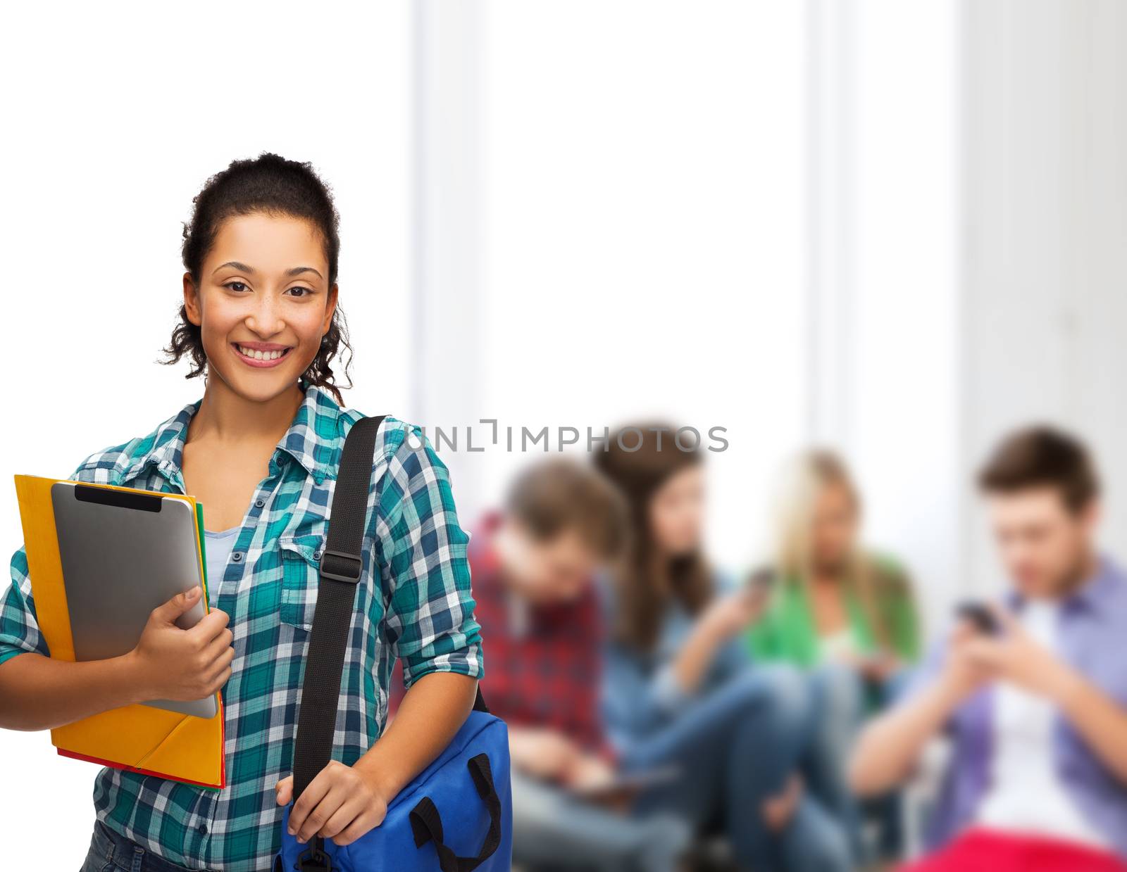 smiling student with folders, tablet pc and bag by dolgachov