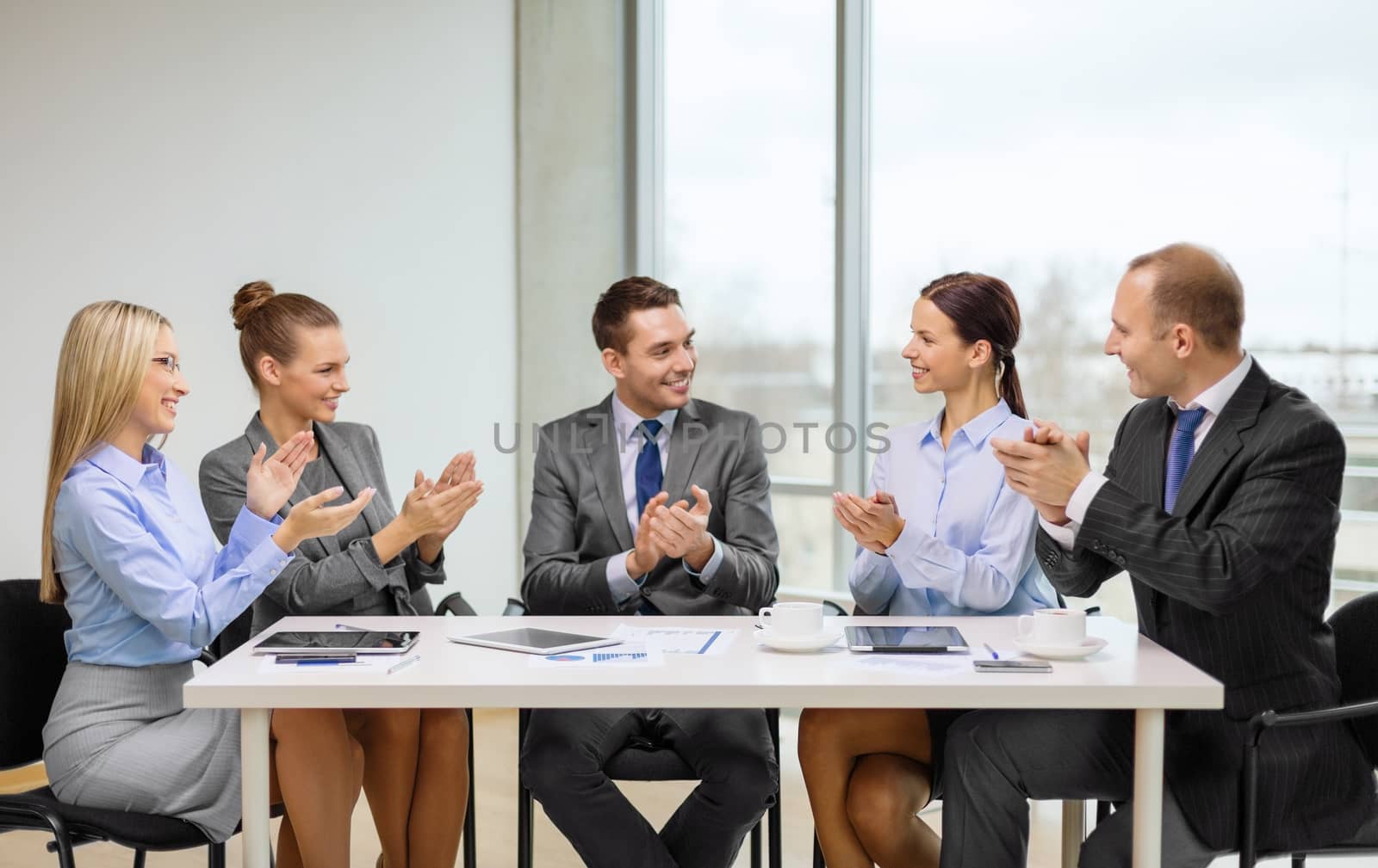 business team with laptop clapping hands by dolgachov