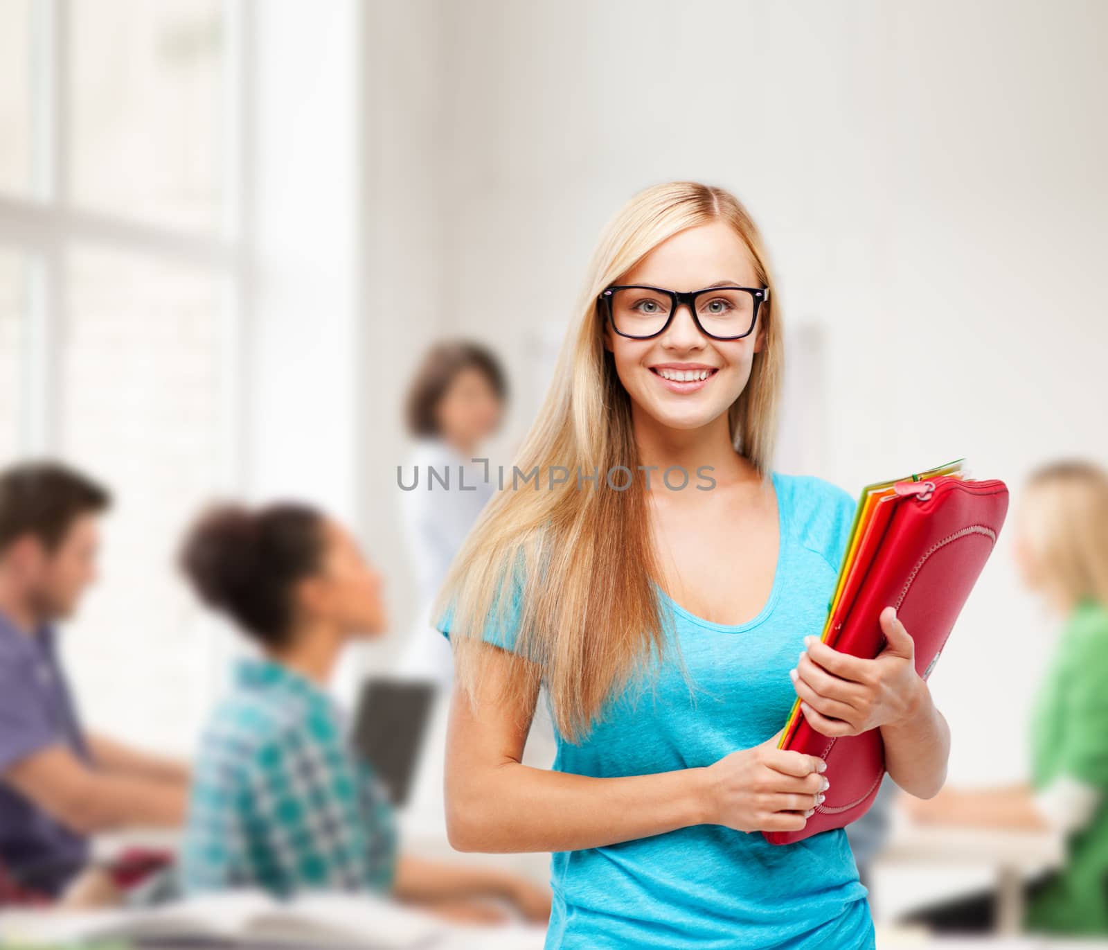 smiling student with folders in eyeglasses by dolgachov