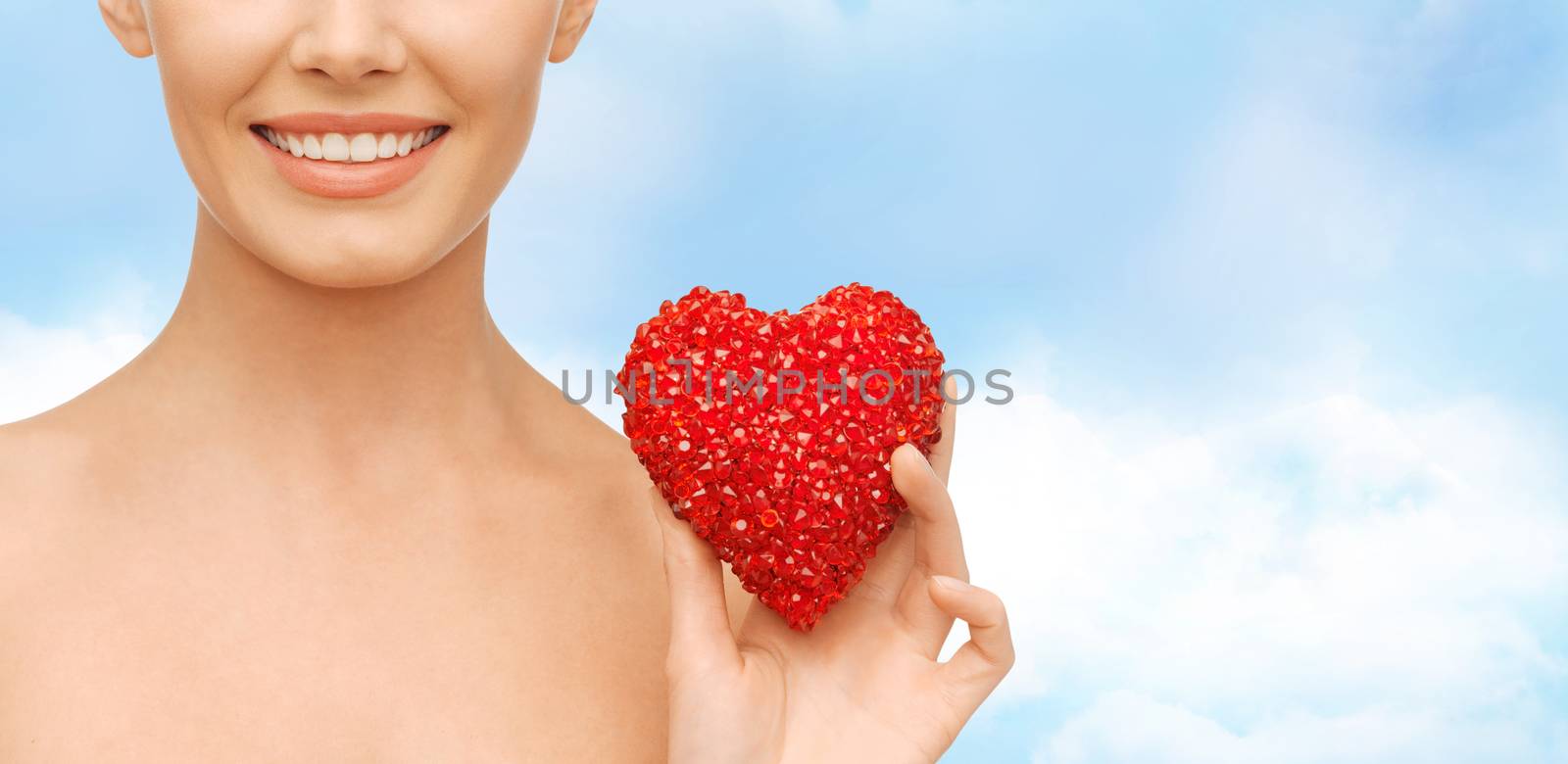 health, beauty and charity concept - beautiful woman with red heart