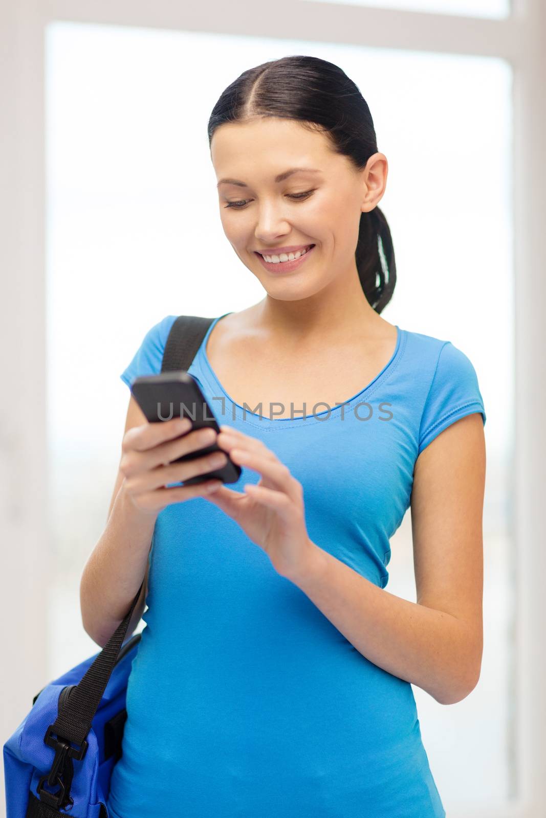education, technology, communication and school concept - smiling female student with smartphone and bag at school