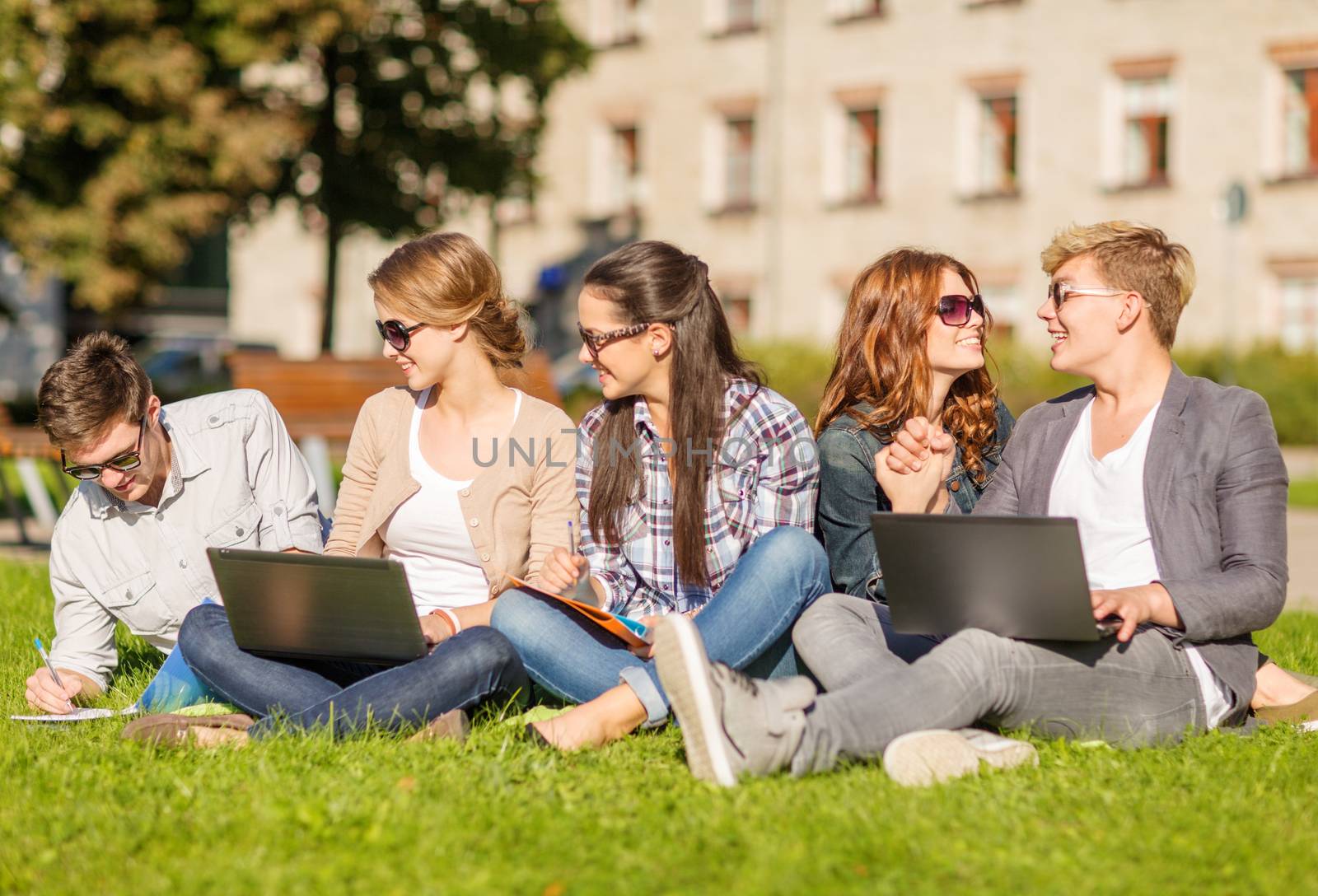summer, internet, education, technlogy and campus concept - group of students or teenagers with laptop, notebooks, files and folders