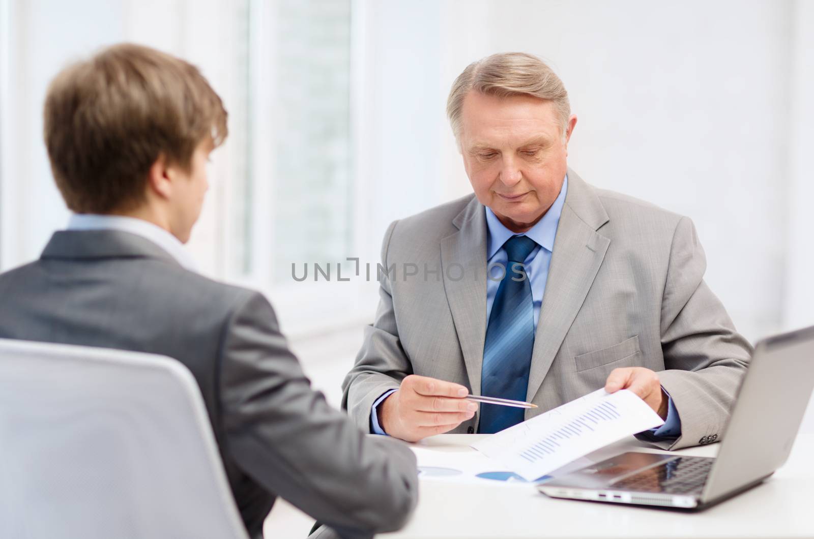 older man and young man having meeting in office by dolgachov