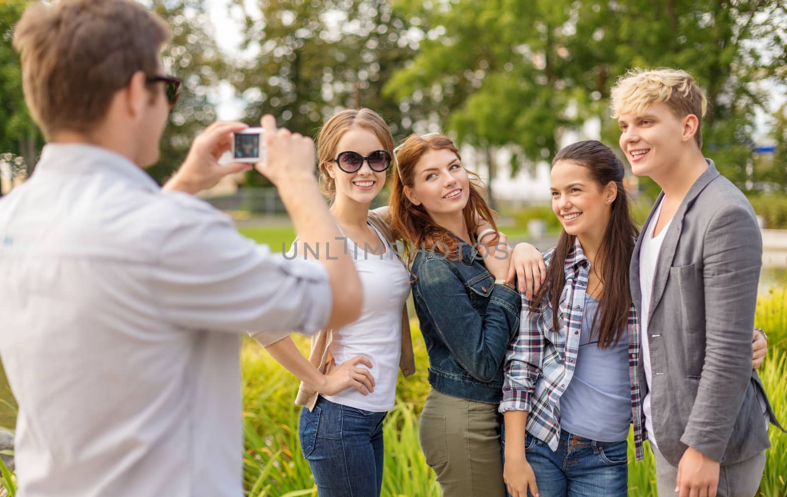 teenagers taking photo digital camera outside by dolgachov