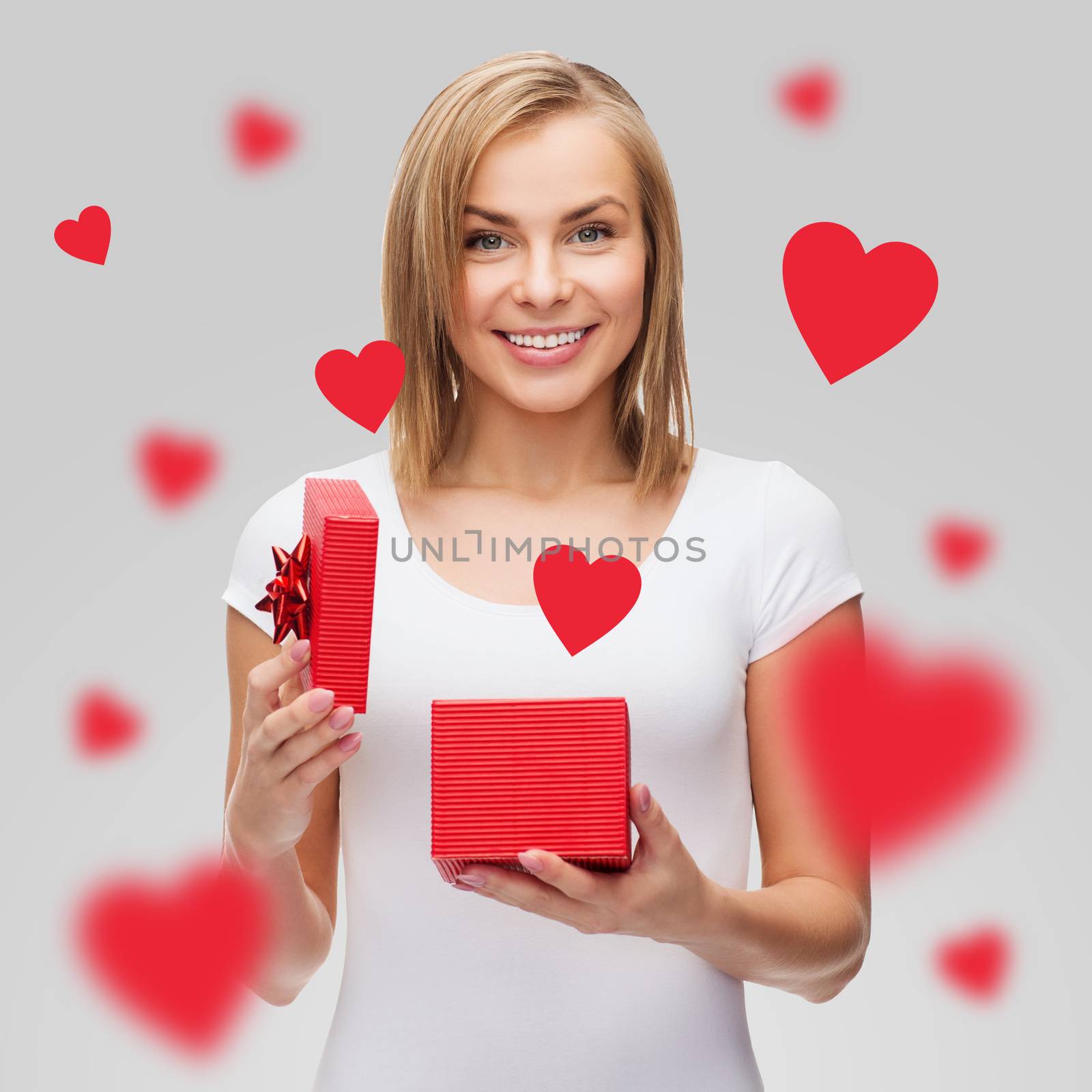 holidays, love, happiness and valentines day concept - beautiful girl with gift box and flying red hearts