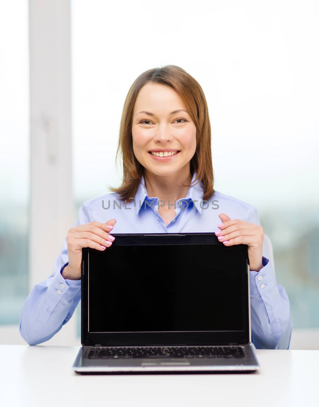 businesswoman with blank black laptop screen by dolgachov