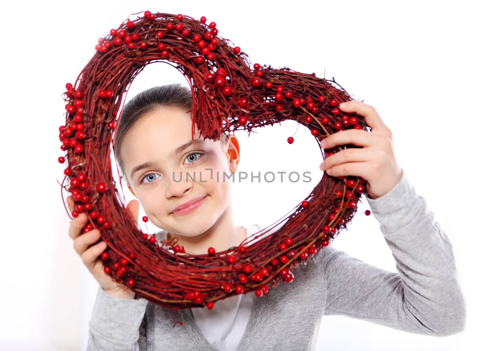 Caucasian girl looking through a red valentines heart