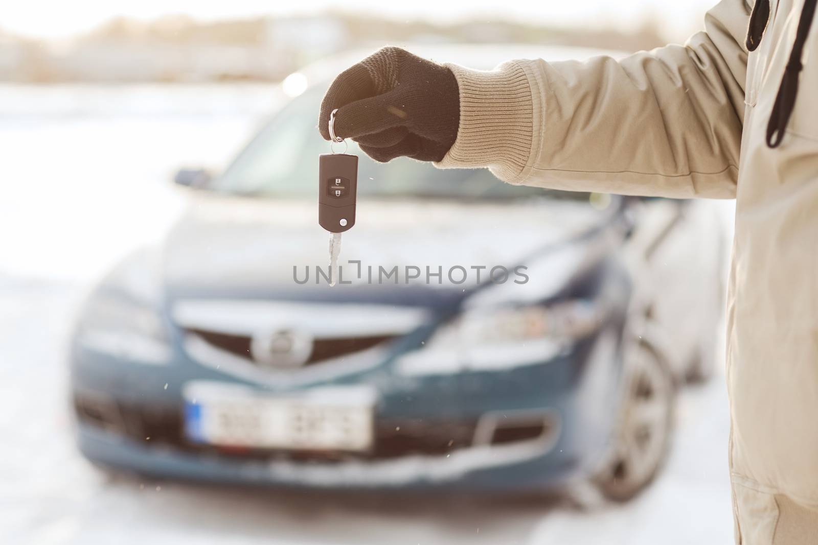 transportation and ownership concept - closeup of man hand with car key outdoors
