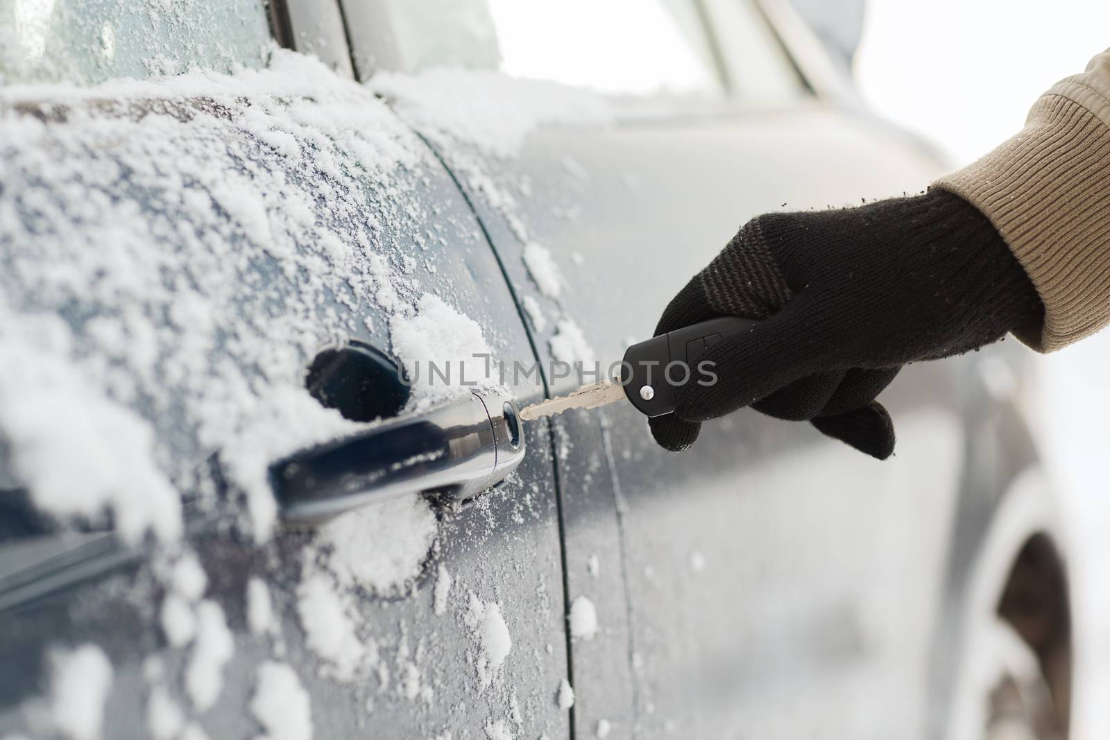 transportation and ownership concept - closeup of man hand opening car with key