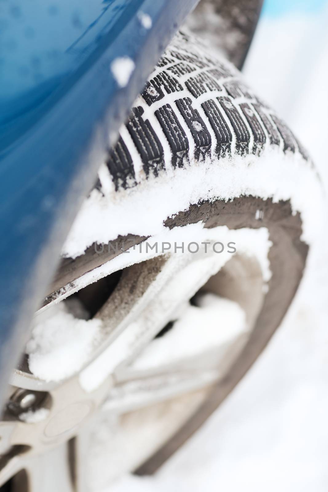 transportation, winter and vehicle concept - closeup of car winter tire