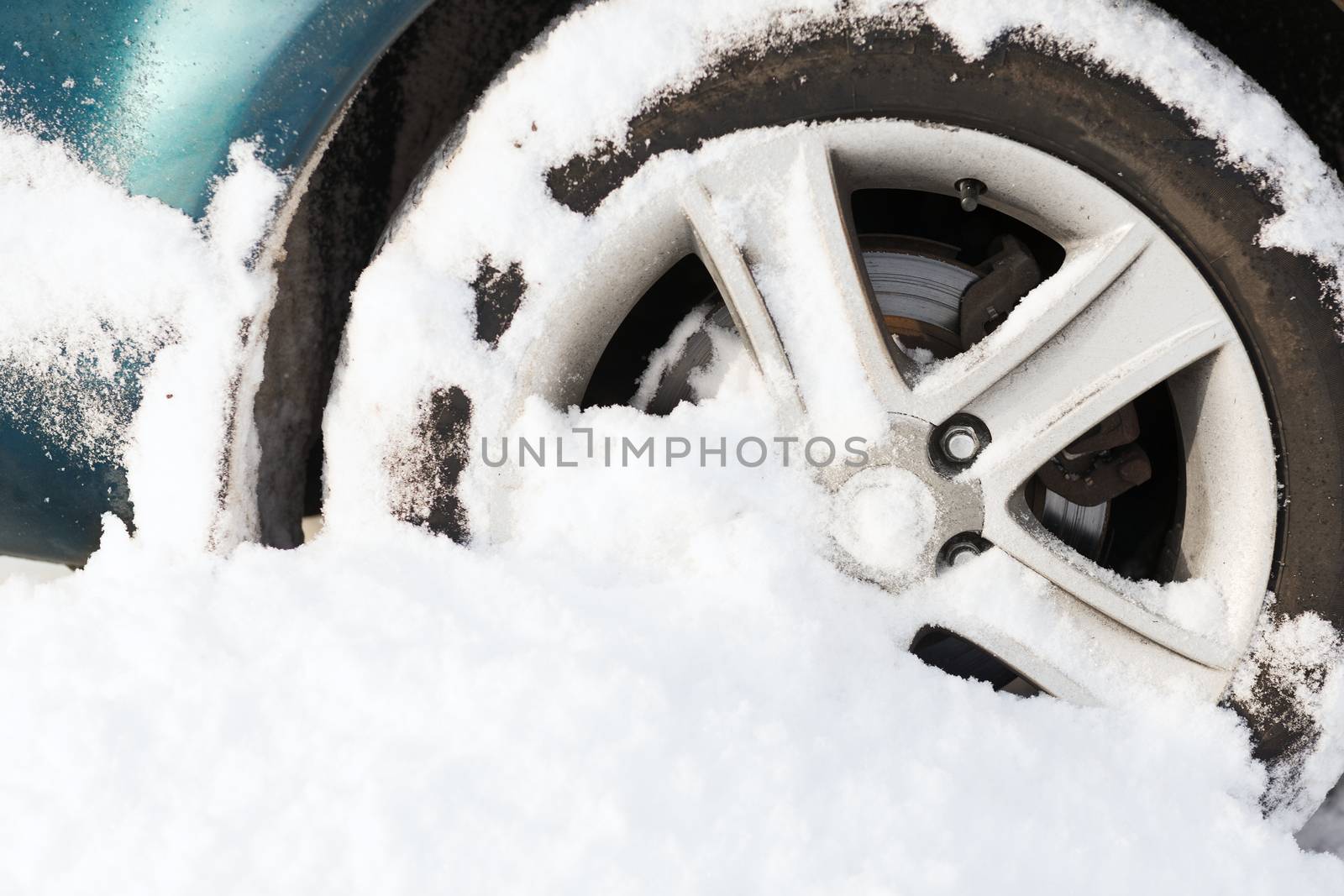closeup of car wheel stuck in snow by dolgachov