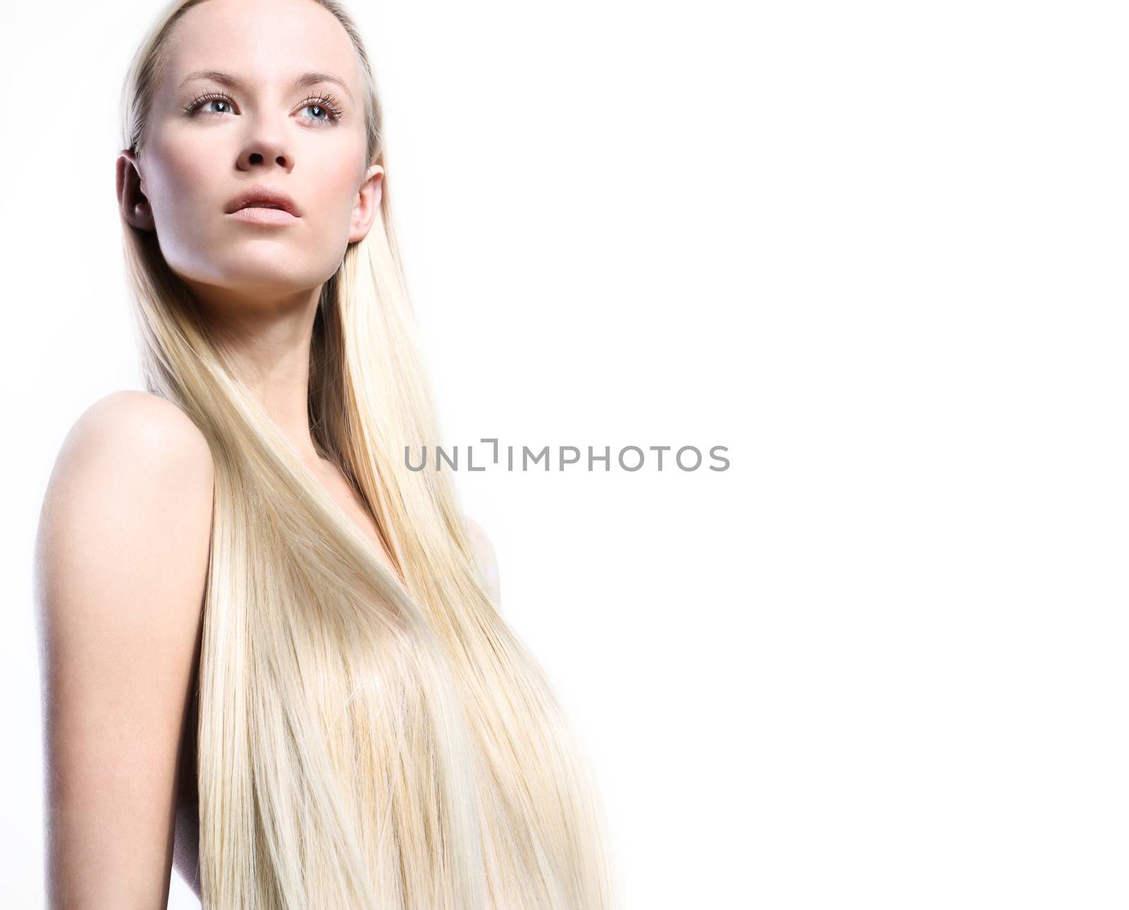 Beautiful long-haired woman in a natural makeup nude on a light background