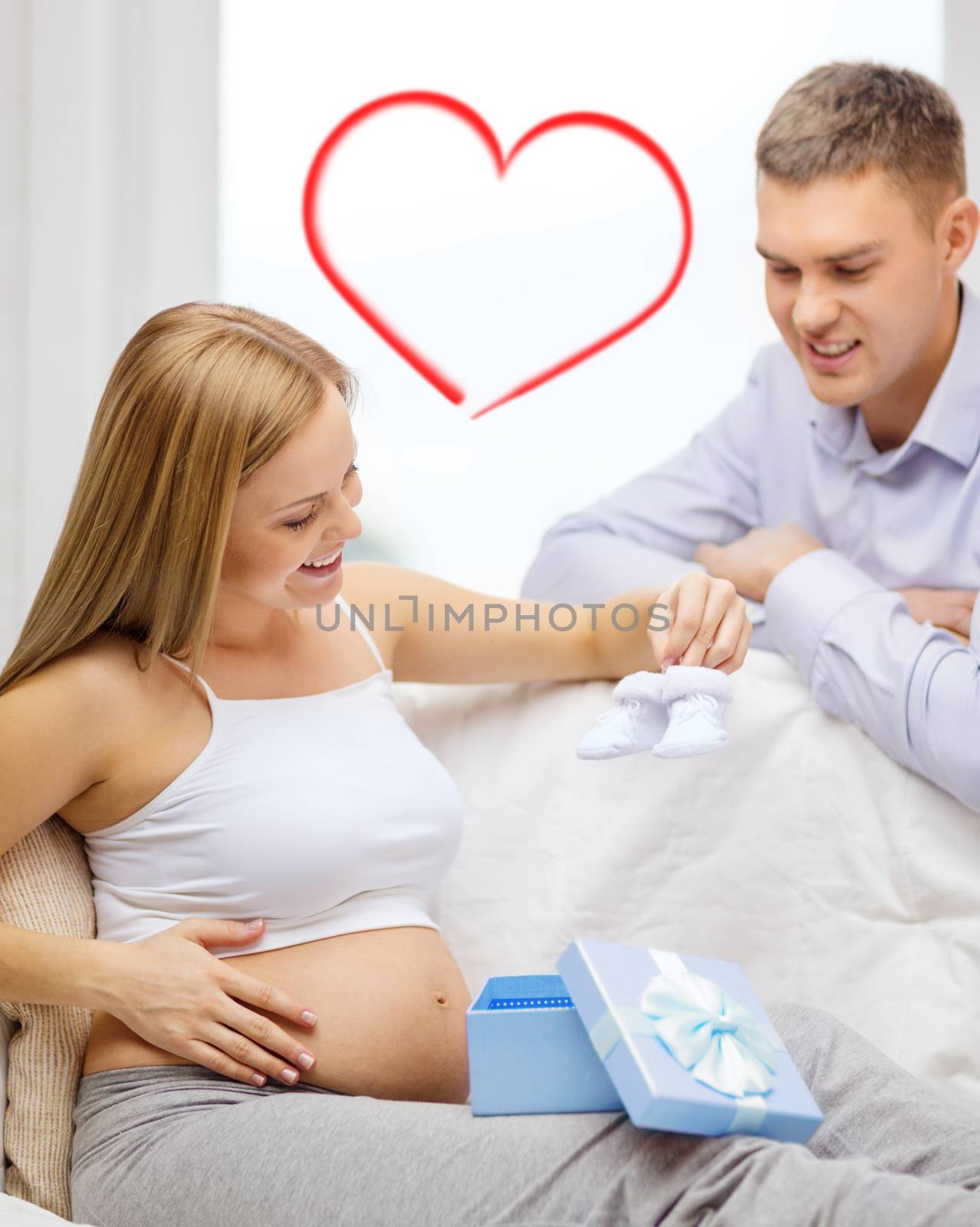 family expecting child with gift box and bootees by dolgachov