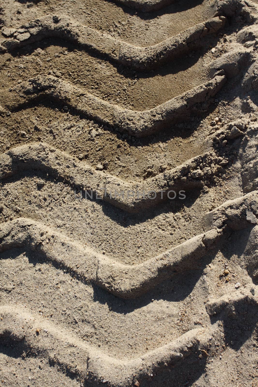 Big heavy tractor wheel tracks in the sand.