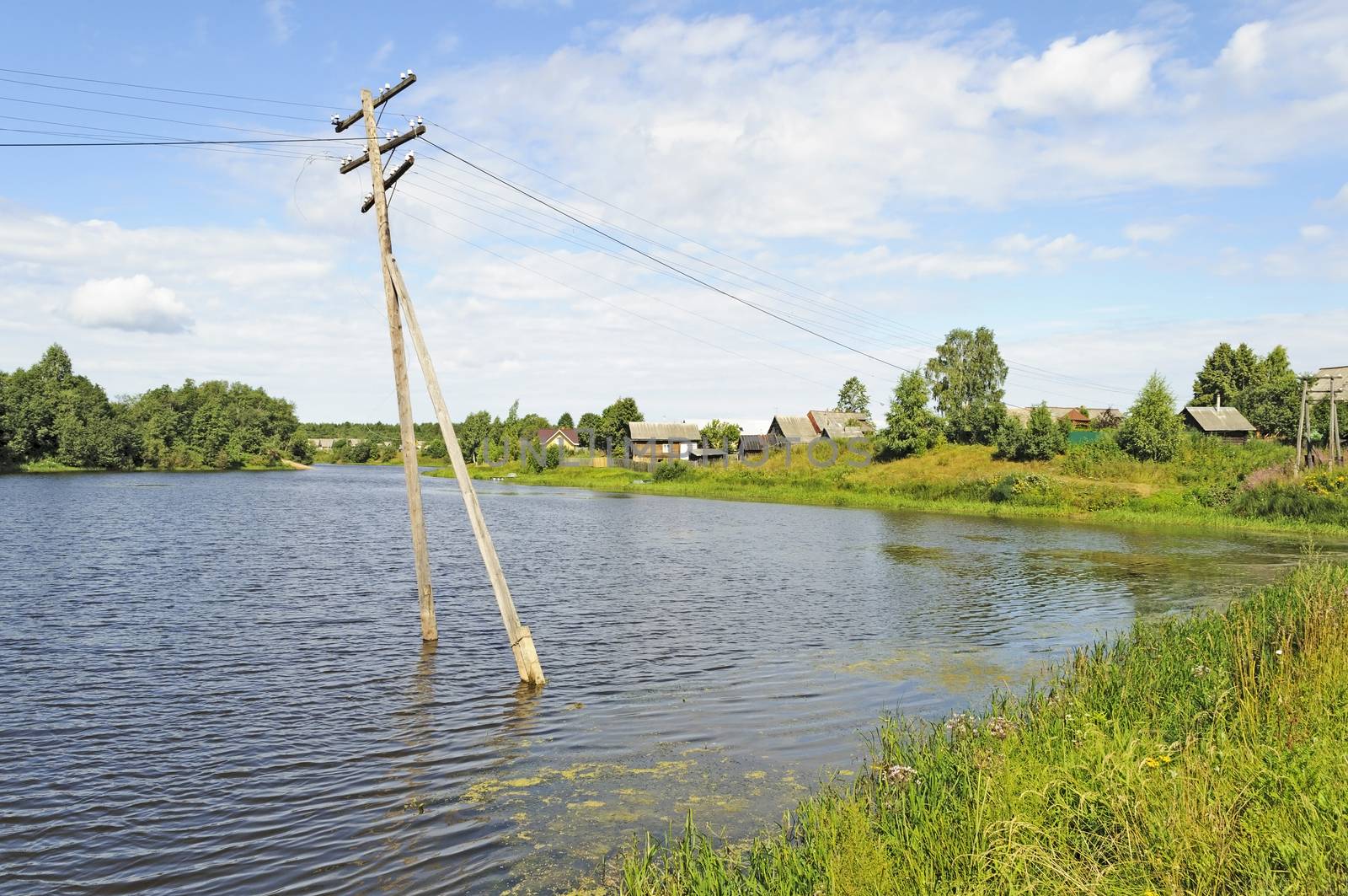 Electric pole in water during a river flood. Country landscape