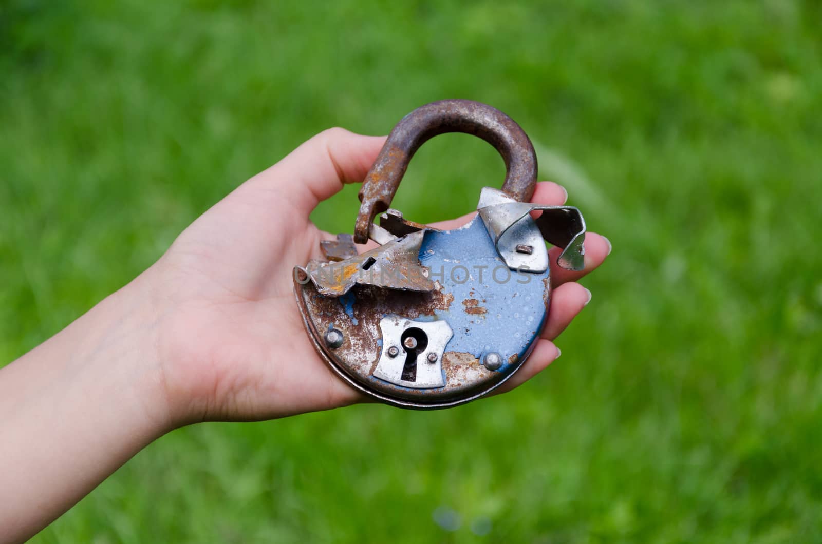 old rusty broken door lock on man hand outdoor by sauletas