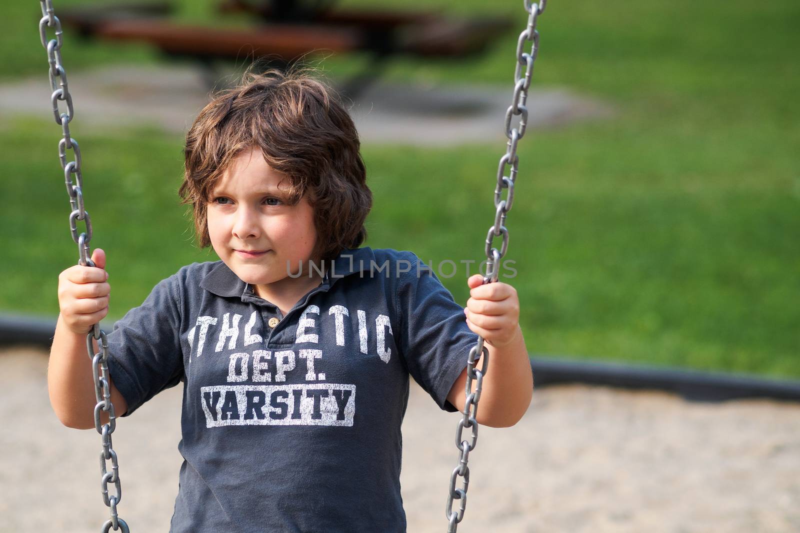 Boy sitting on a swing by Talanis