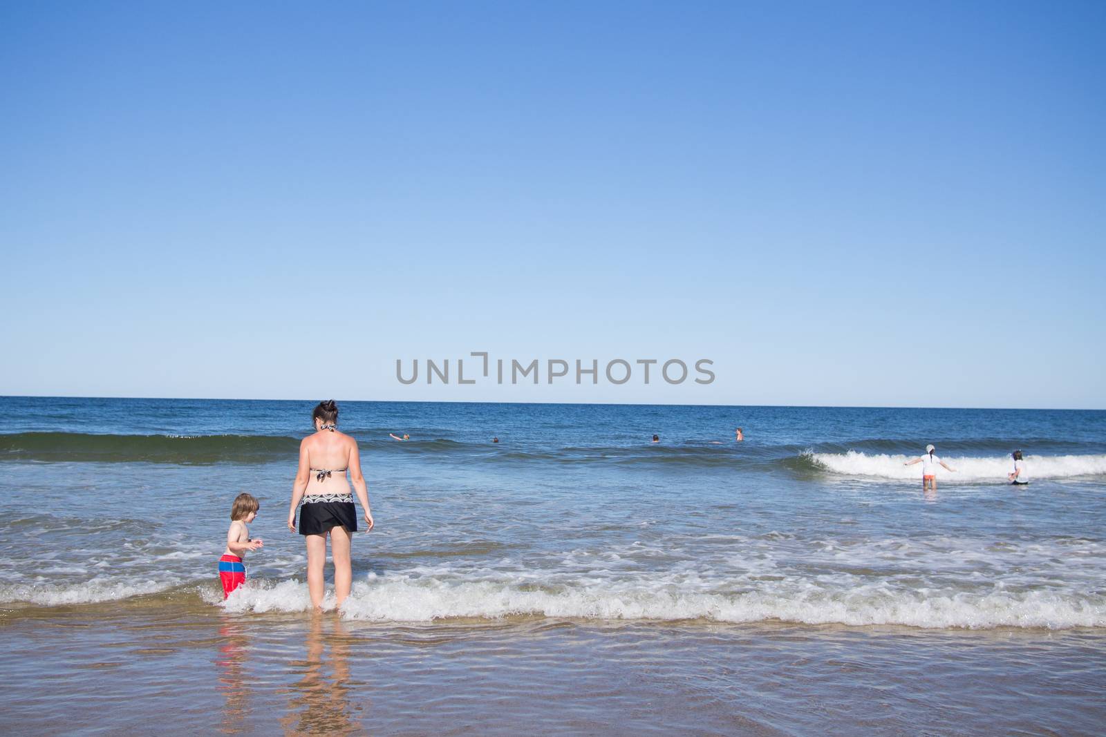Mother and son playing in the water at the sea